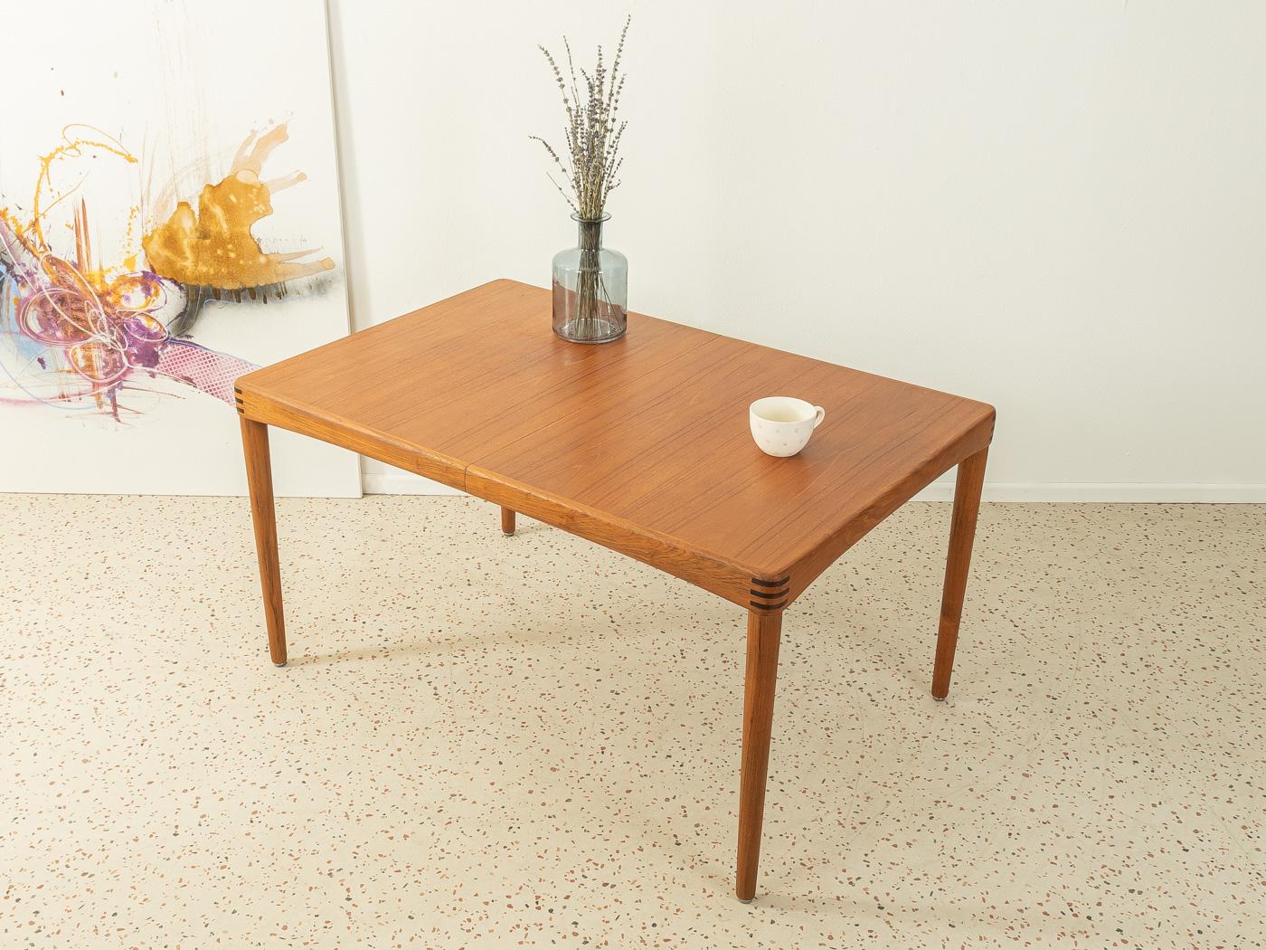Classic extendable teak dining table from the 1960s by H.W. Klein for Bramin. Solid frame and veneered table top with solid wood edge. The insert plate can be stowed under the table top.

Quality features:
- accomplished design: perfect