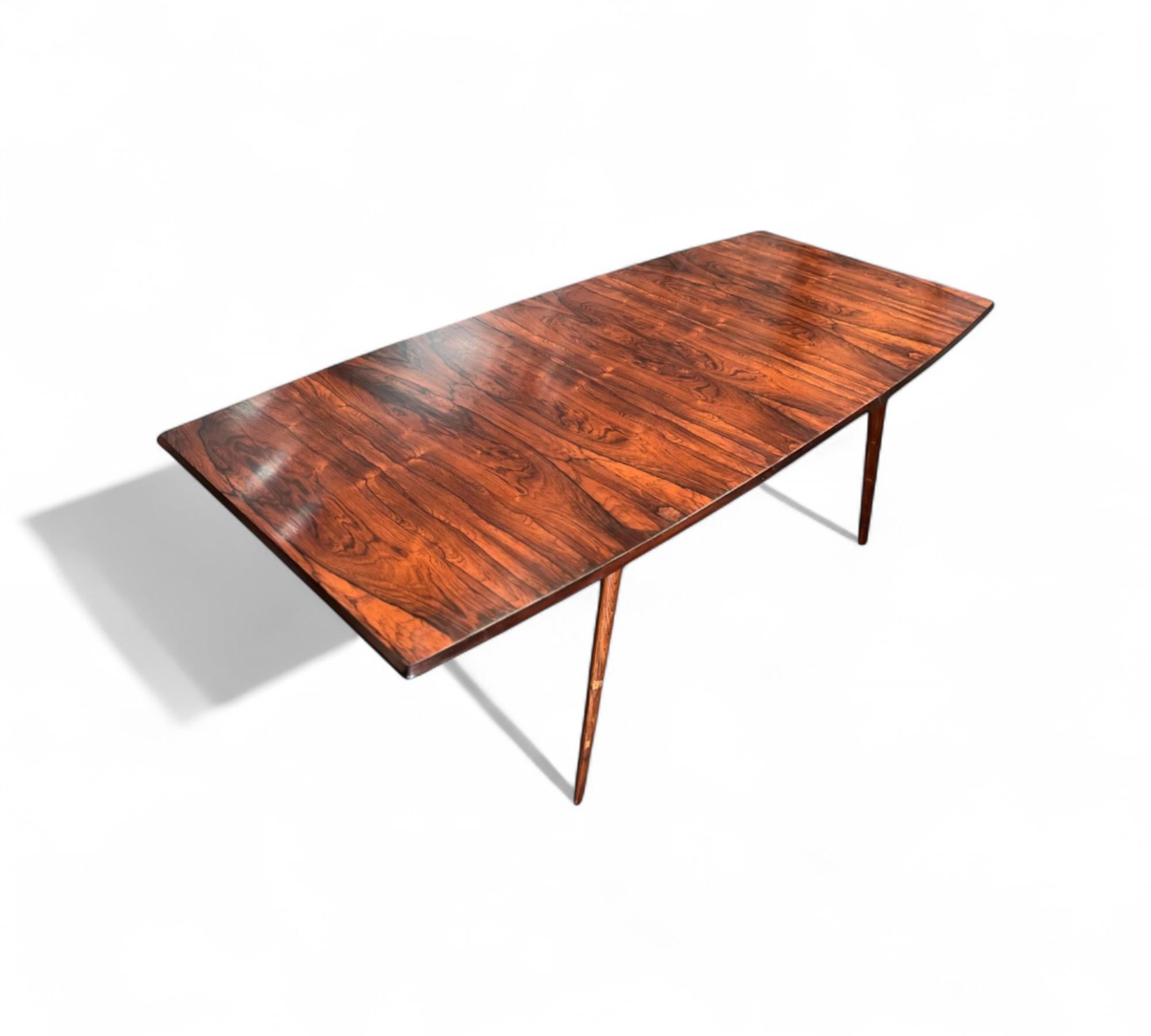 This dining table, crafted from solid Brazilian rosewood, boasts an extendable tabletop that enhances both versatility and functionality. Notably, it is assembled using wood fitting techniques, eschewing screws or nails. The table includes a