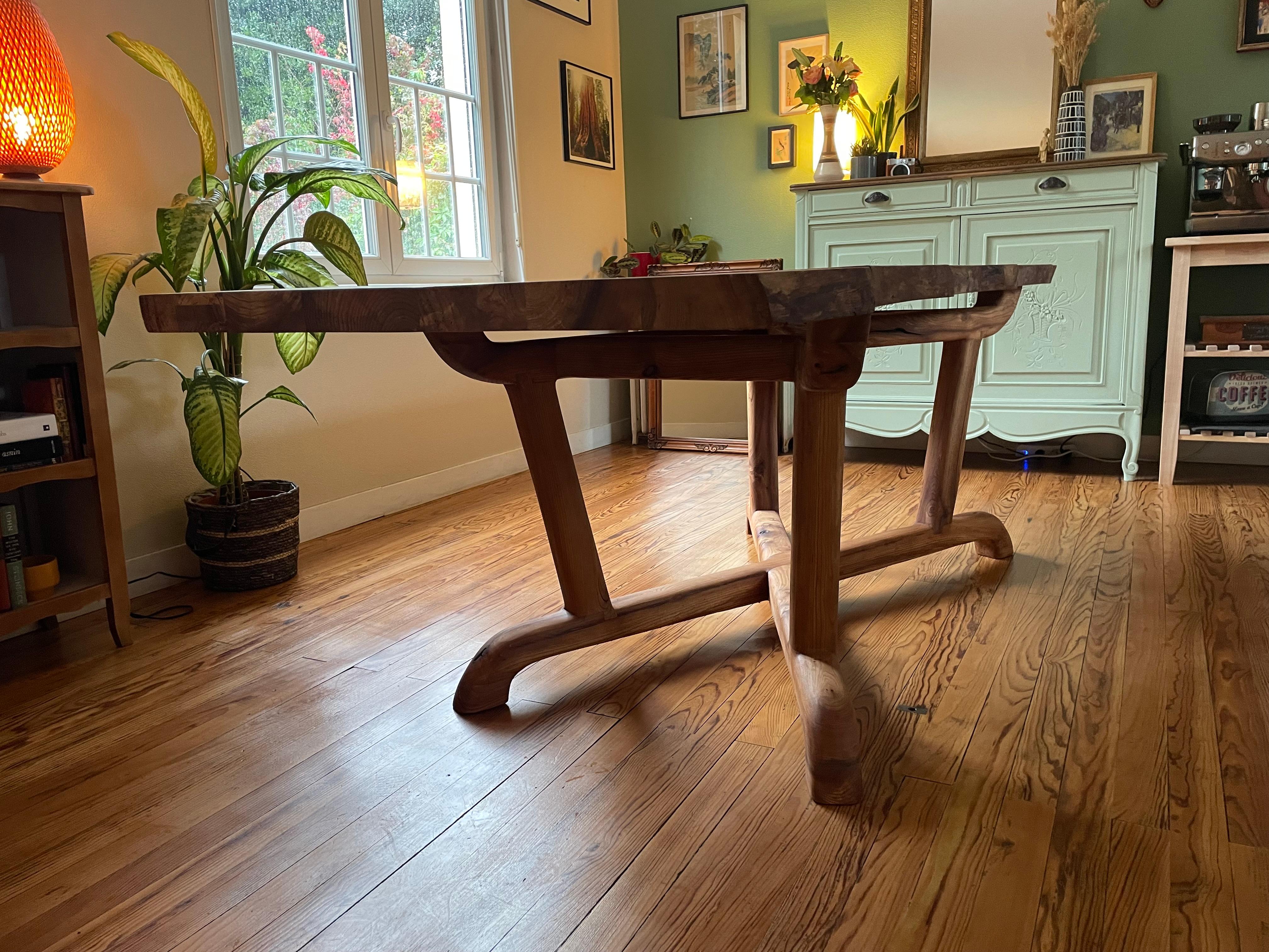 Une table de salle à manger rustique extensible fabriquée à partir de bois d'orme récupéré. Conçu avec un équilibre parfait entre rustique et contemporain, le bord naturel subtil du plateau de table se fond dans la forme organique de la base avec