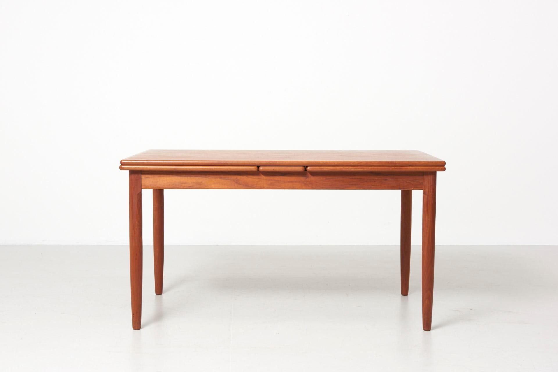 A dining table in teak with 2 pullout / pull-out leaves of 60 cm each. Made in Denmark.