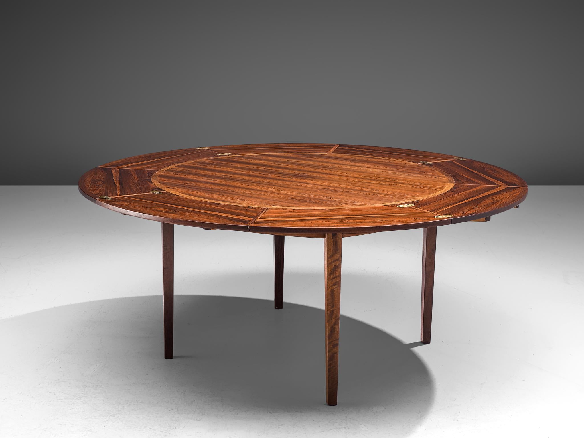 Dyrlund, round extendable dining table, rosewood and brass, Denmark, 1960s.

A circular, extendable table by Dyrlund made with beautiful rosewood, that shows dark flames. Besides the fact that this is a stunning piece, the table is also very