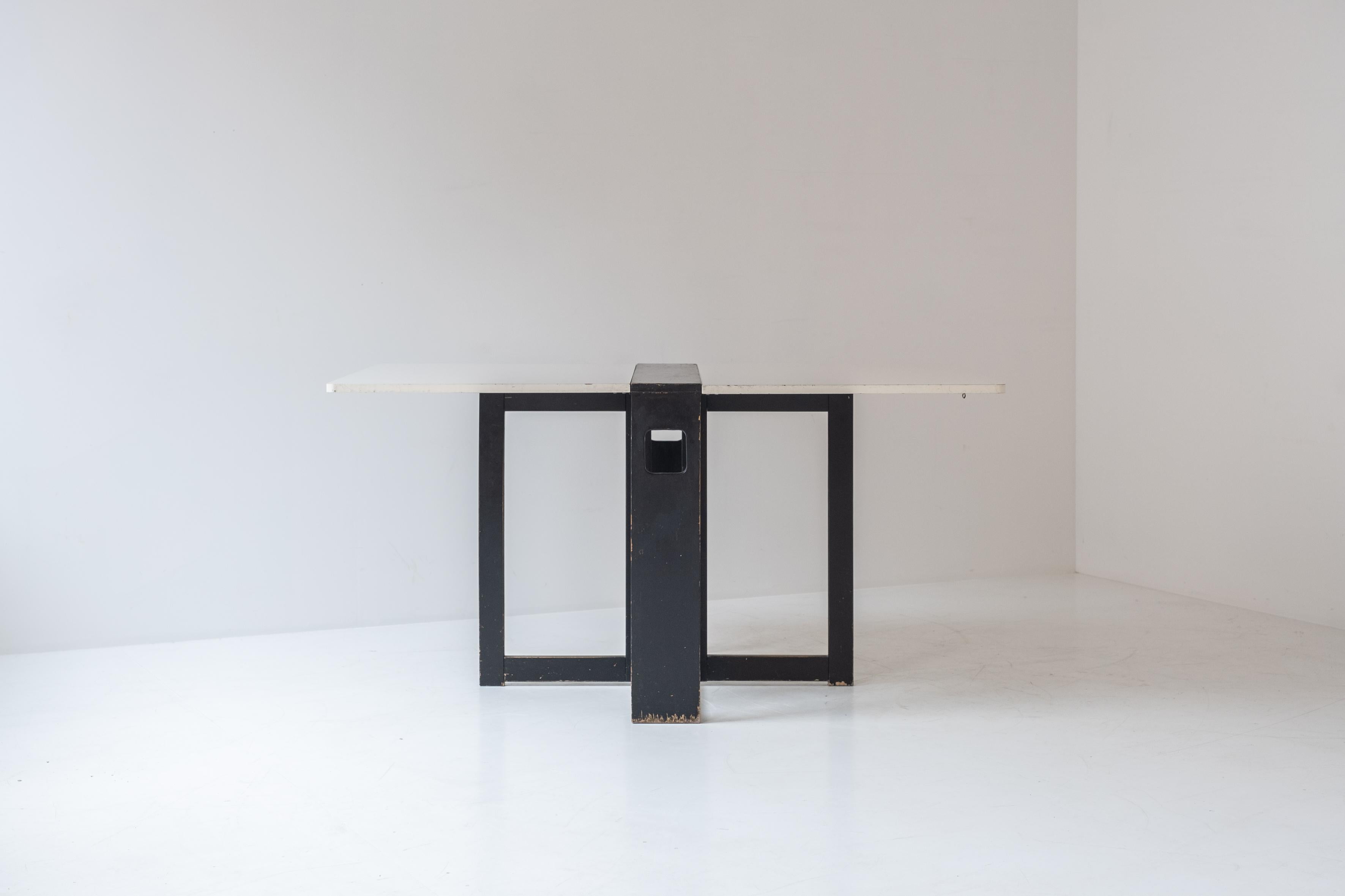 Extendable dining table with architectural base, Belgium 1960s. This folding table features two extensions and can therefore be set up in multiple positions depending on your needs. The base is made out of black lacquered wood and the extensions