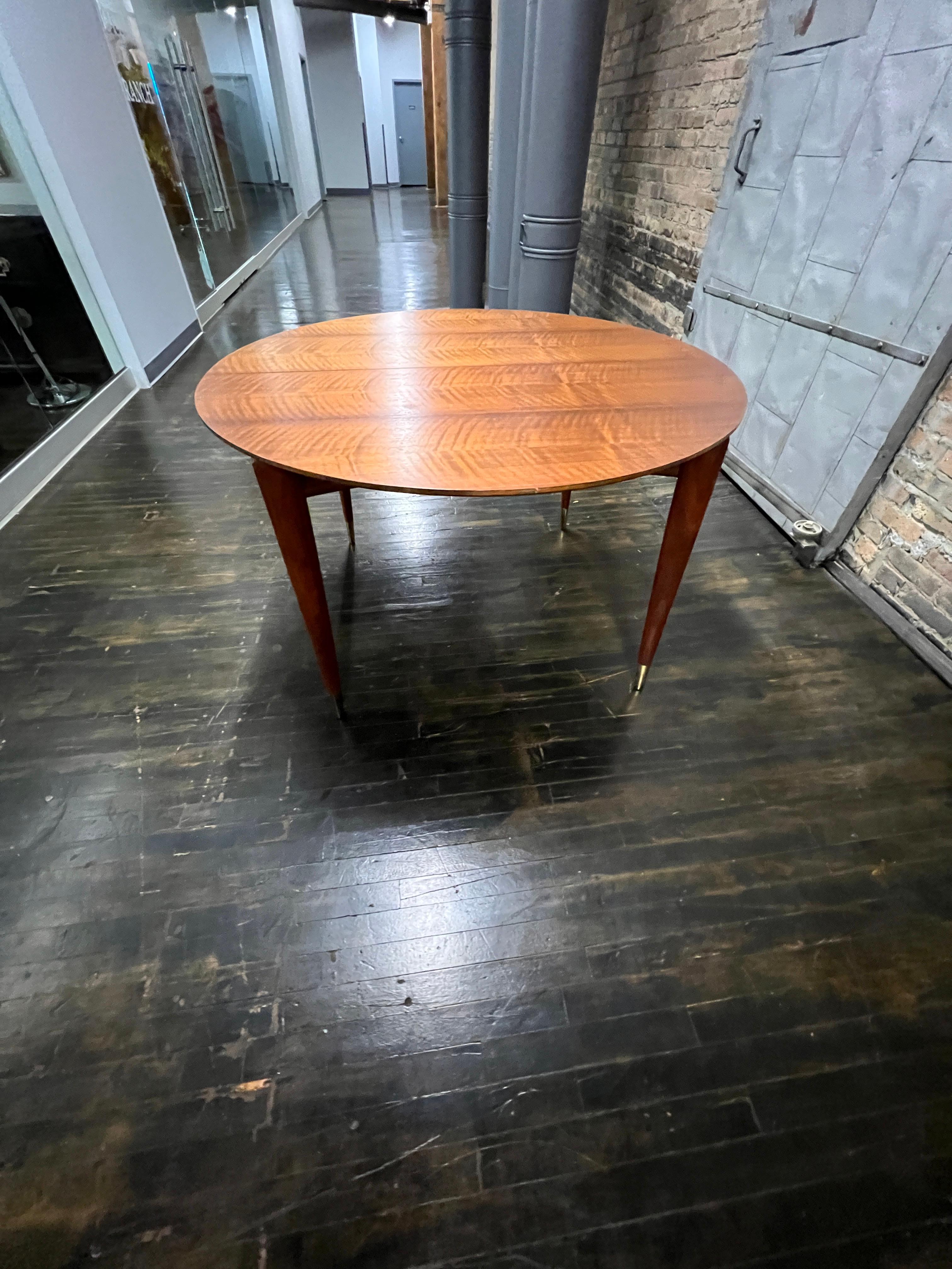 This Model 2135 extendable dining table with four leaves by Gio Ponti (for Singer & Sons) is in near perfect original condition.  It  was constructed with gorgeously veined Italian walnut (the wood is so beautiful it appears to glow and the center
