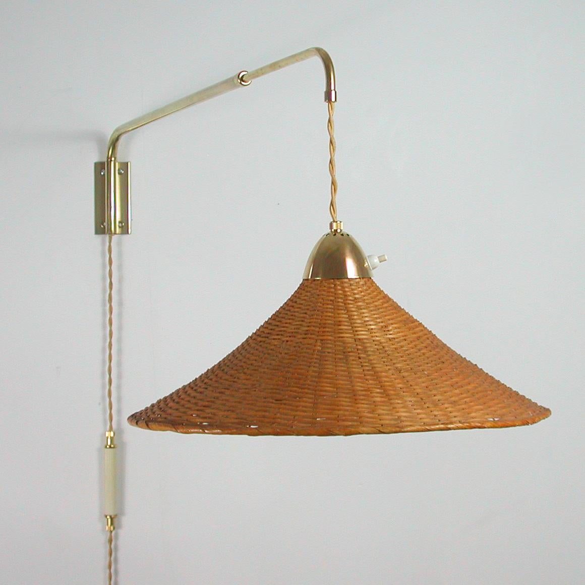 This large telescopic swing-arm wall light was designed and manufactured by J.T. Kalmar, Vienna circa 1950. The brass arm can be extended and swiveled and the shade can be adjusted up-and-down. There is a counterweight on the cord which allows