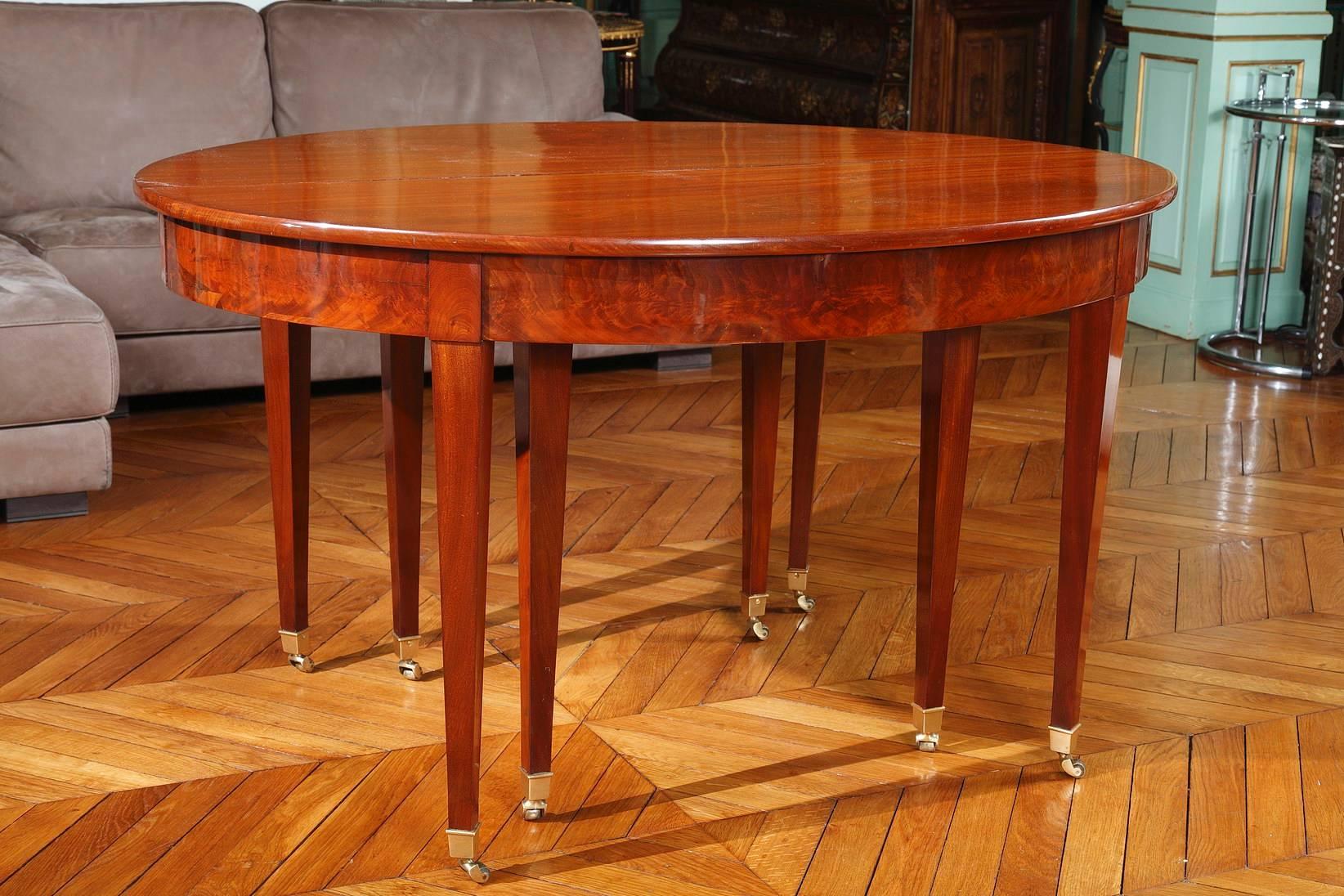 Mahogany dining room table for 10 to 16 seats settings from the Directory period. The table is composed of five leaves that are each almost 20 inches wide (50 cm), making the total length of the table almost 12 feet when opened. When closed, the