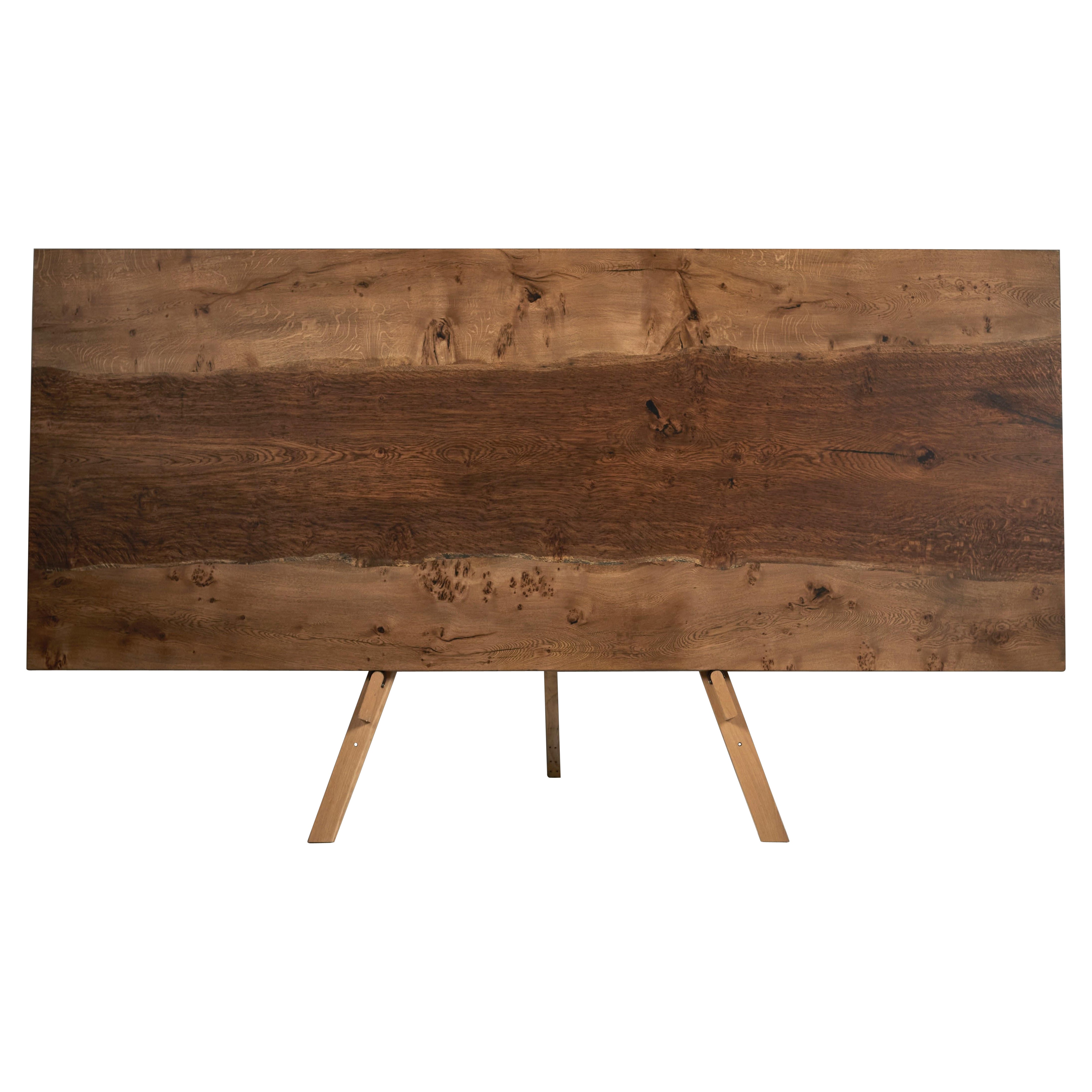 Extendable solid oak table with a central brown oak full-width slab inset into the table top.
The tabletop sits on two curved trapeze legs that are removable for transport. 
The table in the images is 300 cm / 118