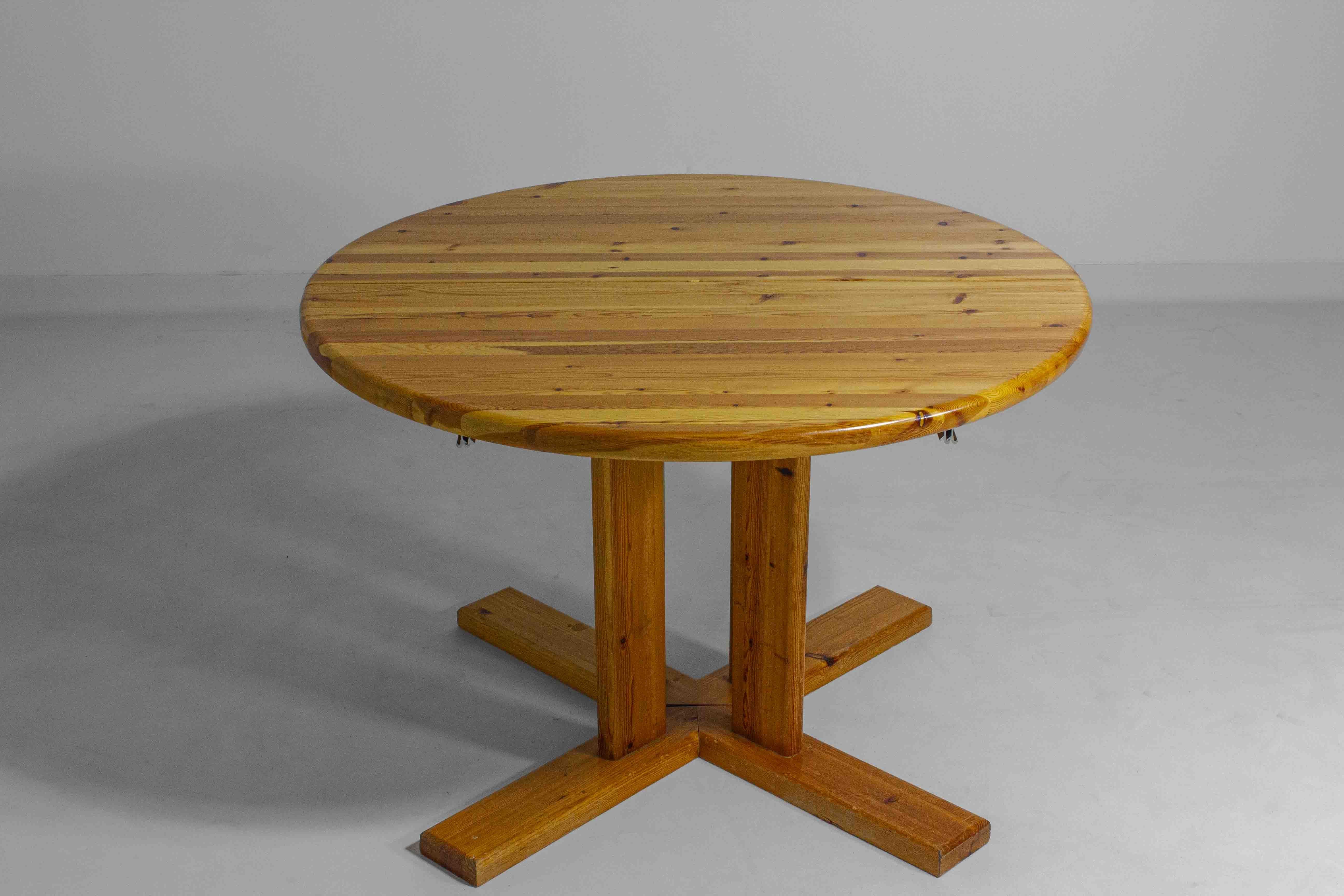 Cette table de salle à manger de Rainer Daumiller est fabriquée en pin massif et peut passer d'une forme ronde à une forme ovale lorsqu'elle est rallongée. Conçue dans les années 1970, la table est simple et pratique, construite pour durer et