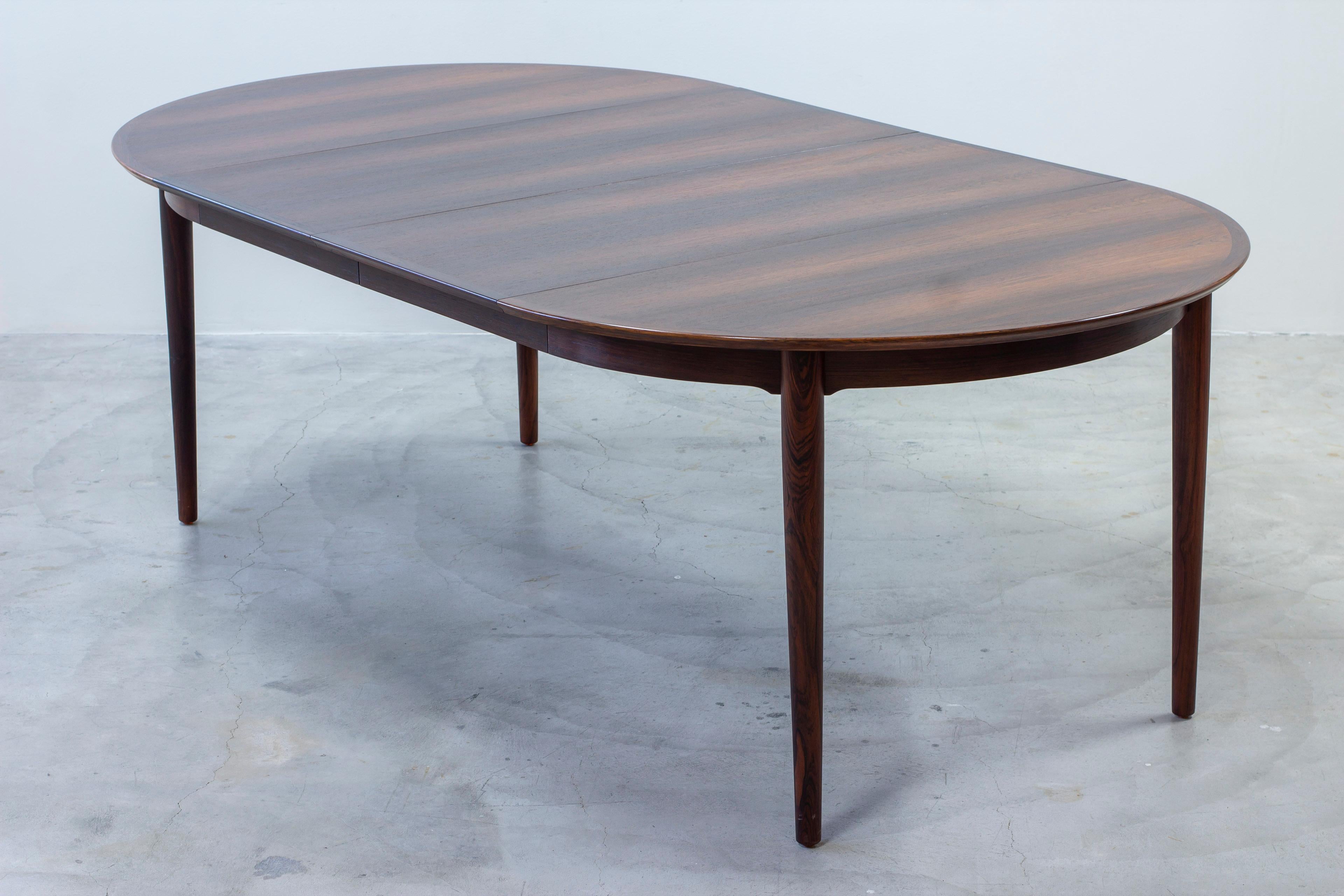 Dining table designed by Arne Vodder. Produced in Denmark by Sibast Furniture during the 1960s.  Made from rosewood veneer on the top and tapered solid rosewood legs. Two inlays extending the table to 219 cm, seating up to eight people comfortably.