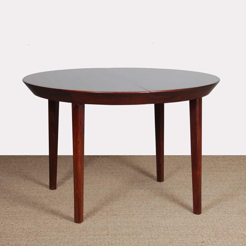 This Scandinavian round table was designed by Ole Hald for Gudme Møbelfabrik. It is a Danish production in rio rosewood from the 1960s. It includes 2 extension leaves, each measuring 48.5 cm. This dining table is in good vintage condition.