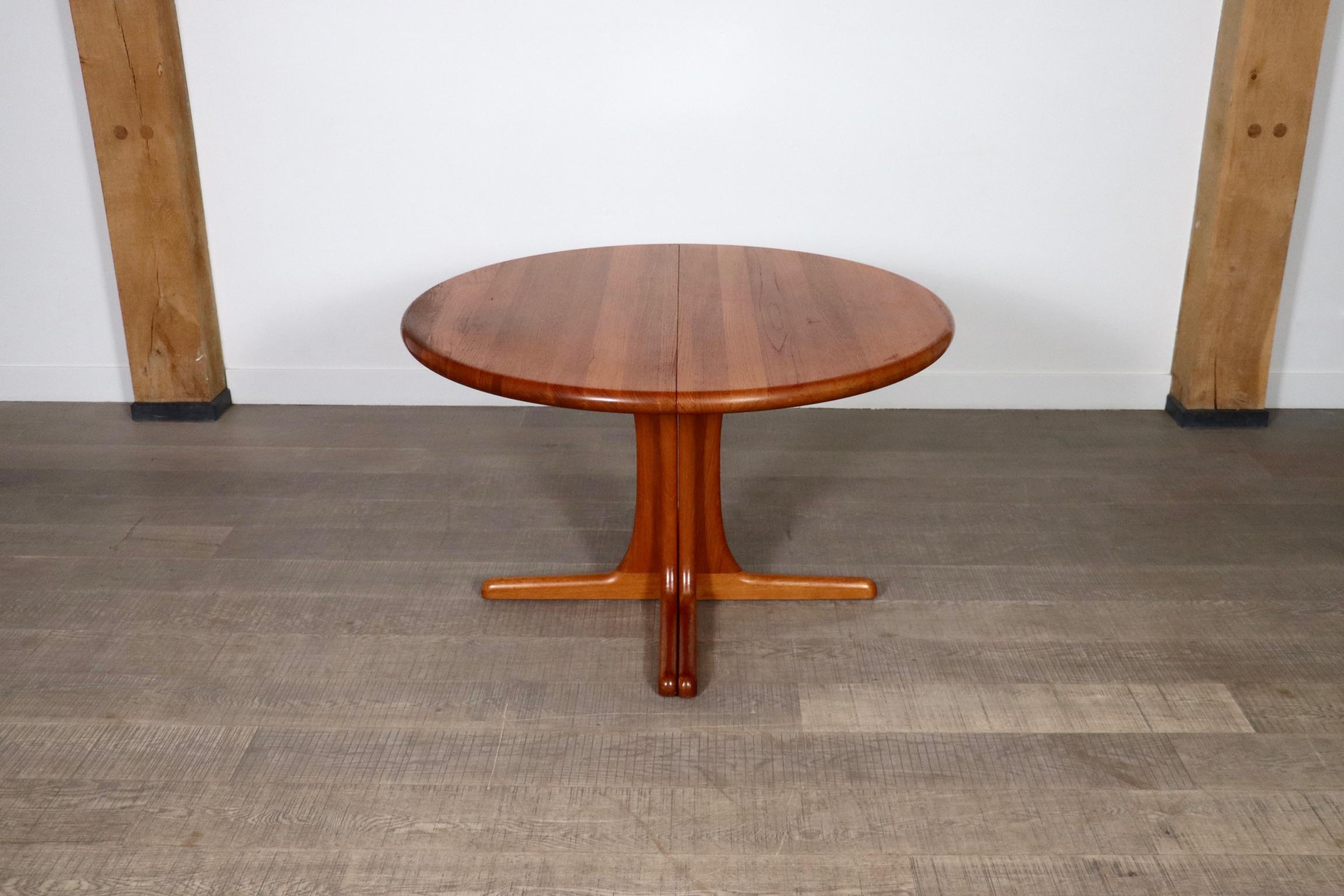 Beautiful solid teak extendable round to oval dining table, Denmark 1960s. A clever design which is beautiful in each setting, and can fit any space to its needs. Having a dinner party? Just add the two additional table leafs and extend the table to