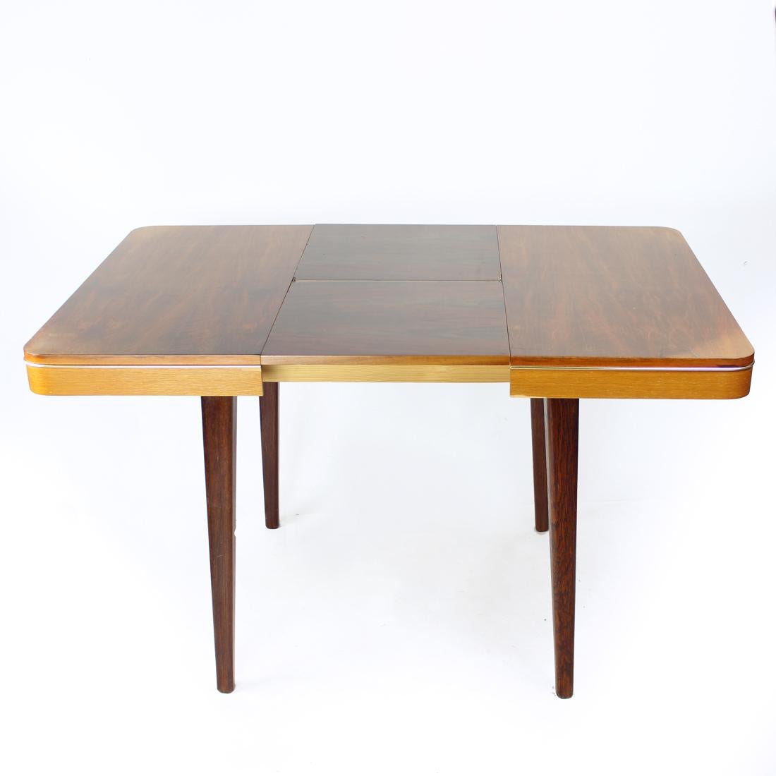 Beautiful dining table produced in 1968, original label still attached. It even says the table is made of oak and walnut wood. the top board is in walnut wood with beautiful veneer on top. The table is easily extendable, just pull the two halfs