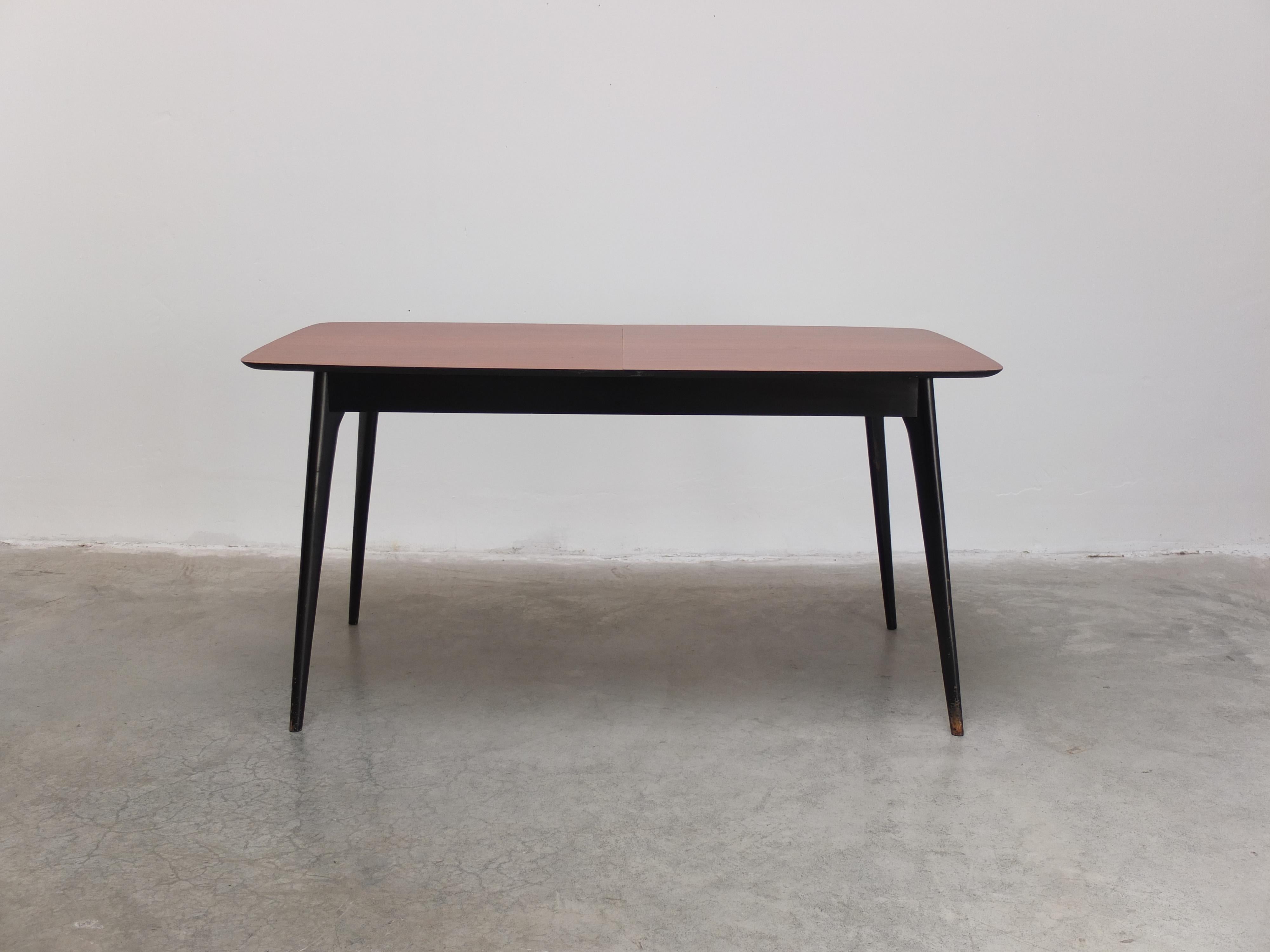 Schöner Esstisch Modell 'T1', entworfen von Alfred Hendrickx für Belform um 1957. Dieser Tisch hat eine Platte aus Zingana-Holz und elegante, schwarz lackierte Beine, die typisch für Hendrickx' Design der fünfziger Jahre sind. Ausziehbar von 150 cm