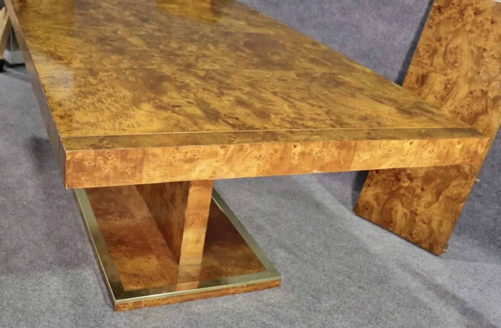 Exquisite mid-century modern dining table by Founders in beautiful bright burl wood grain. Accented with brass trimming. Two extra 16 1/4