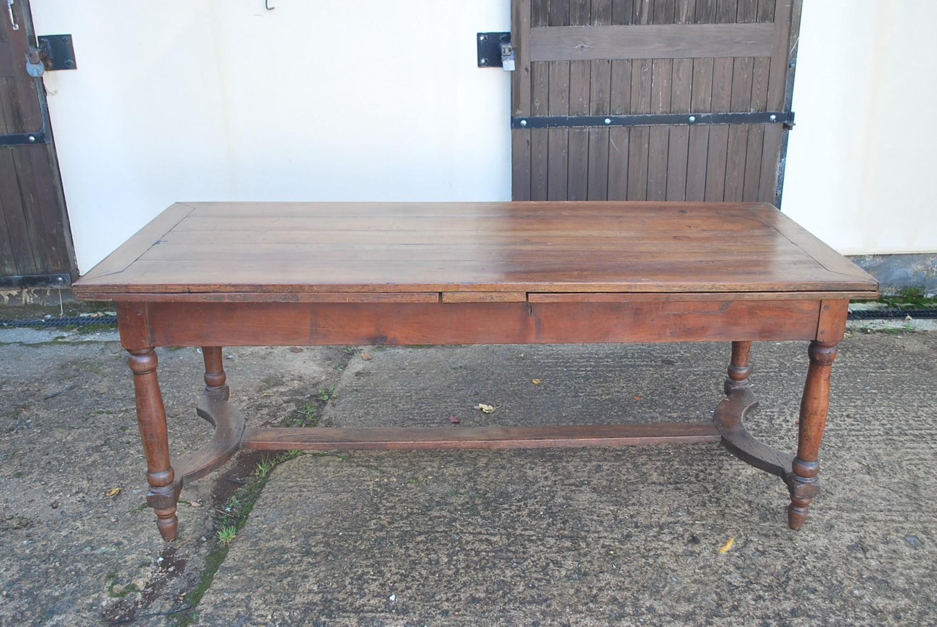 Hutton-Clarke Antiques is delighted to present an exquisite 18th-century French cherry wood extending farmhouse table, a true gem for discerning collectors and enthusiasts. This remarkable piece boasts a rich and captivating patina, showcasing the