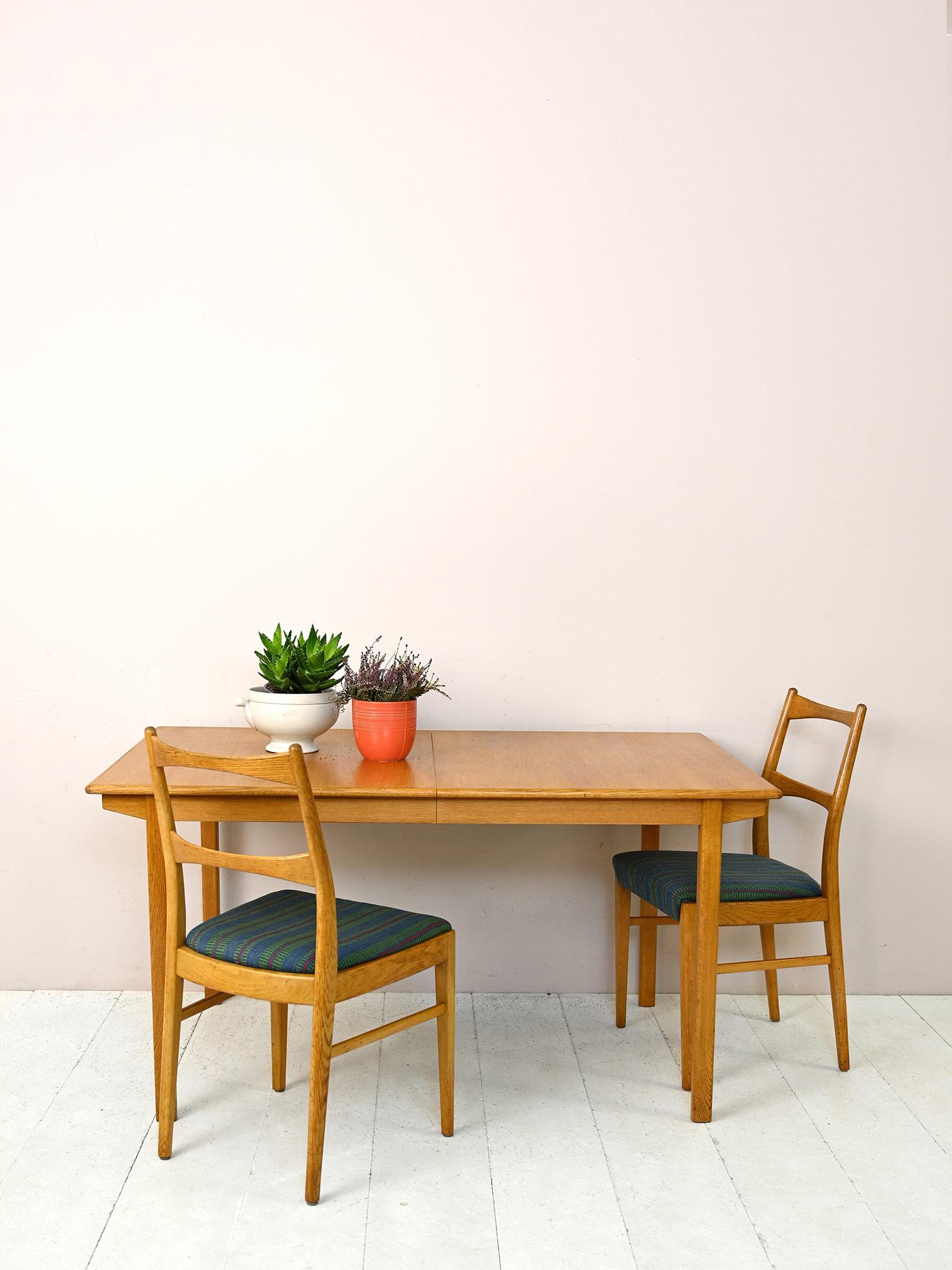 Scandinavian modern antique dining table.

This vintage piece of furniture fits into environments with a young, contemporary style thanks to its modern lines and light color of oak wood.
The presence of an additional central board allows you to