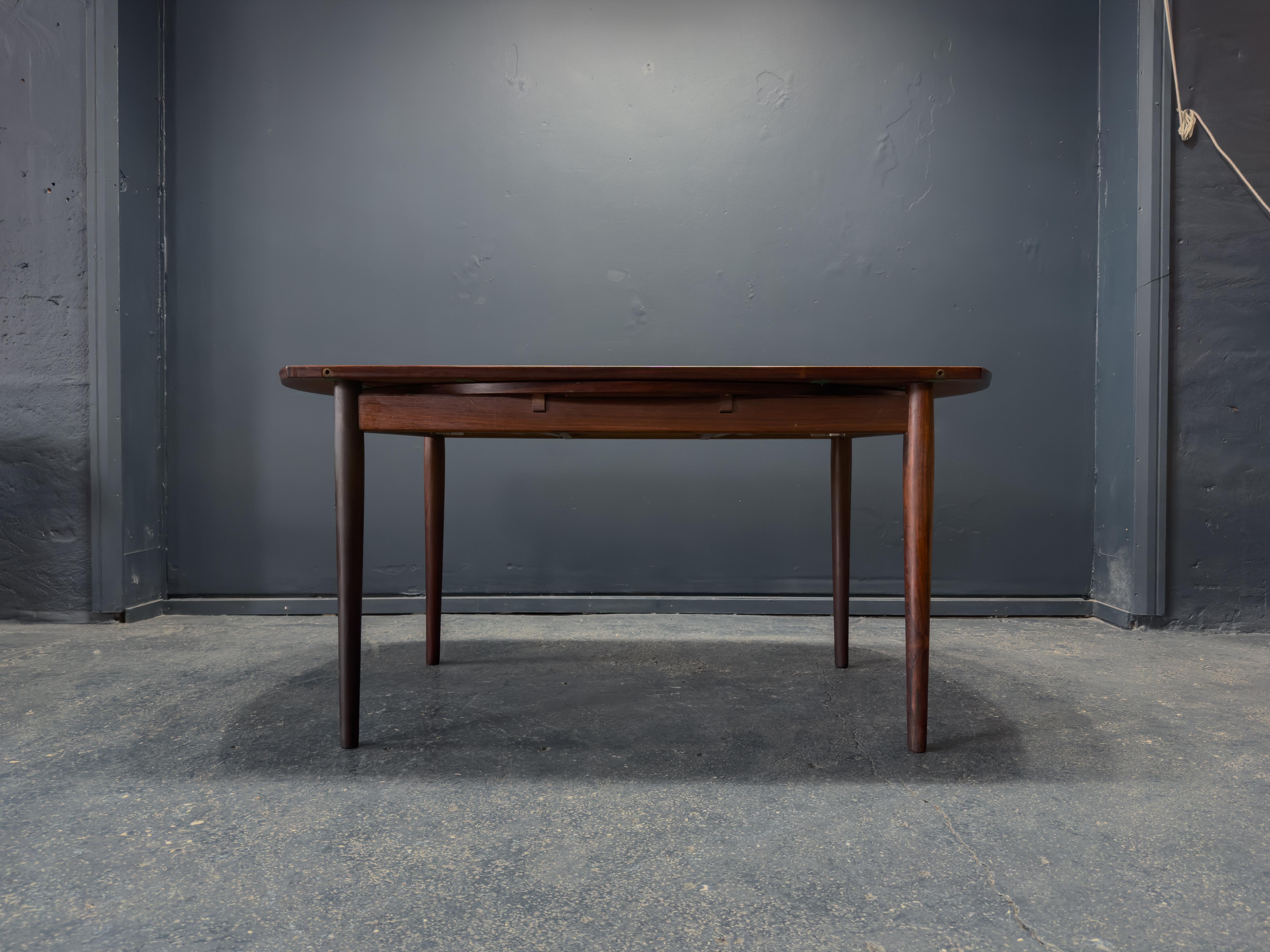 Esta llamativa mesa de comedor redonda de mediados de siglo está fabricada en madera noble, con un veteado bellamente tallado que recorre la superficie a la perfección.

Ingeniosamente diseñada, presenta dos hojas desplegables que se deslizan por