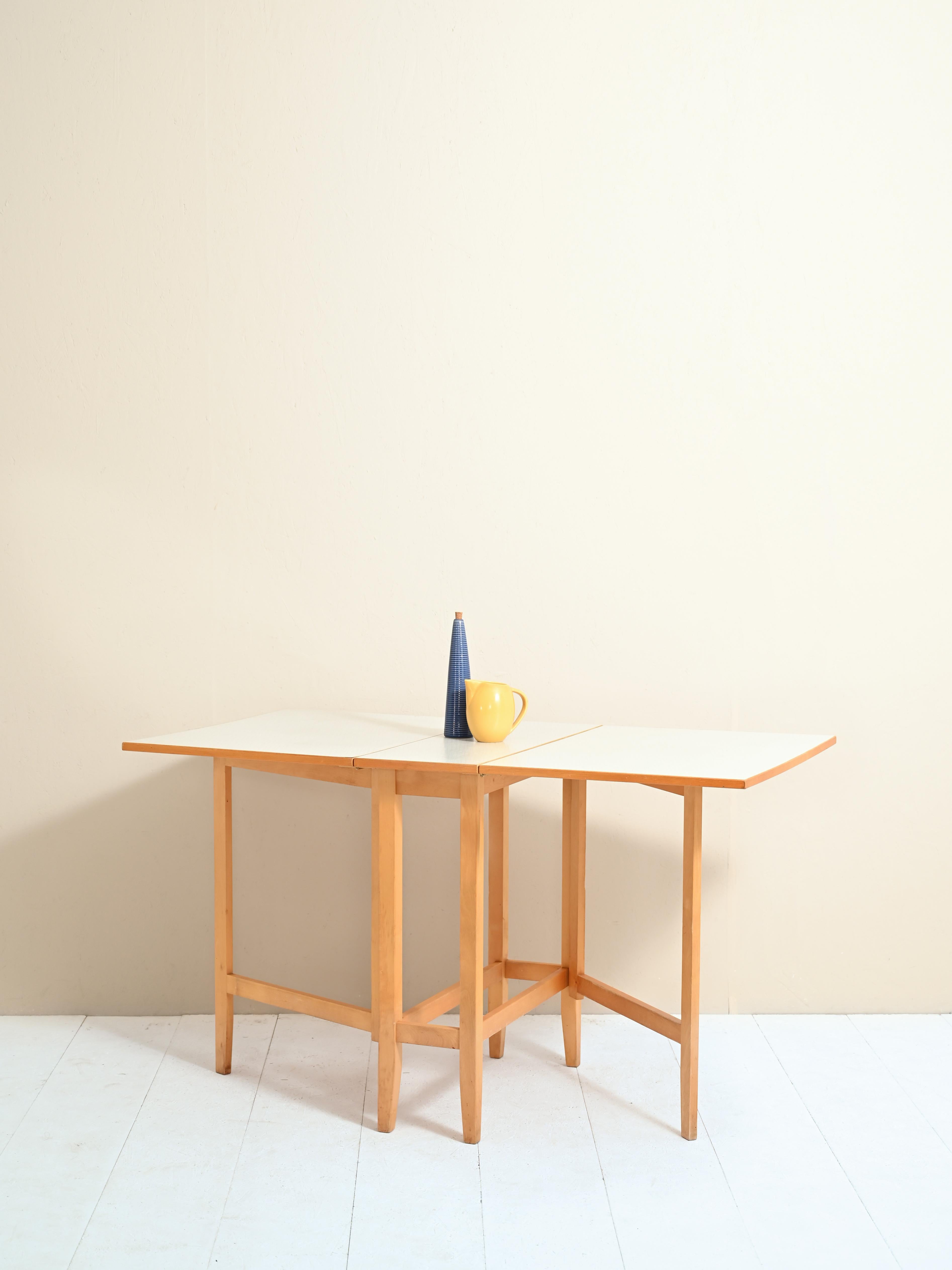Scandinavian table made of wood and formica top.
This wing-opening model is called 'Slagbord' (translated to 'battle table') in Swedish,
A sturdy dining table extendable on both sides, which can comfortably seat 6
people. 

Dimensions:
Height