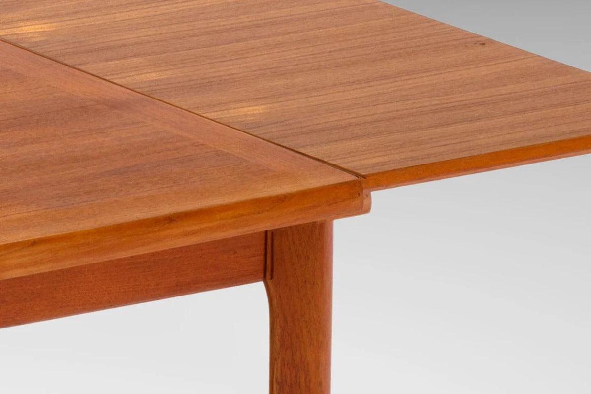 Teak dinning table by Henning Kjærnulf for Vejle Stole Møbelfabrik. The table features two extension leaves that are cleverly stowed in the table for maximum convenience and increasing the seating capacity from six to eight comfortably. Perfect both