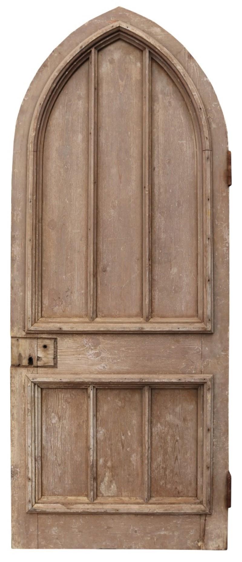 A salvaged antique arched external door of solid pine construction.