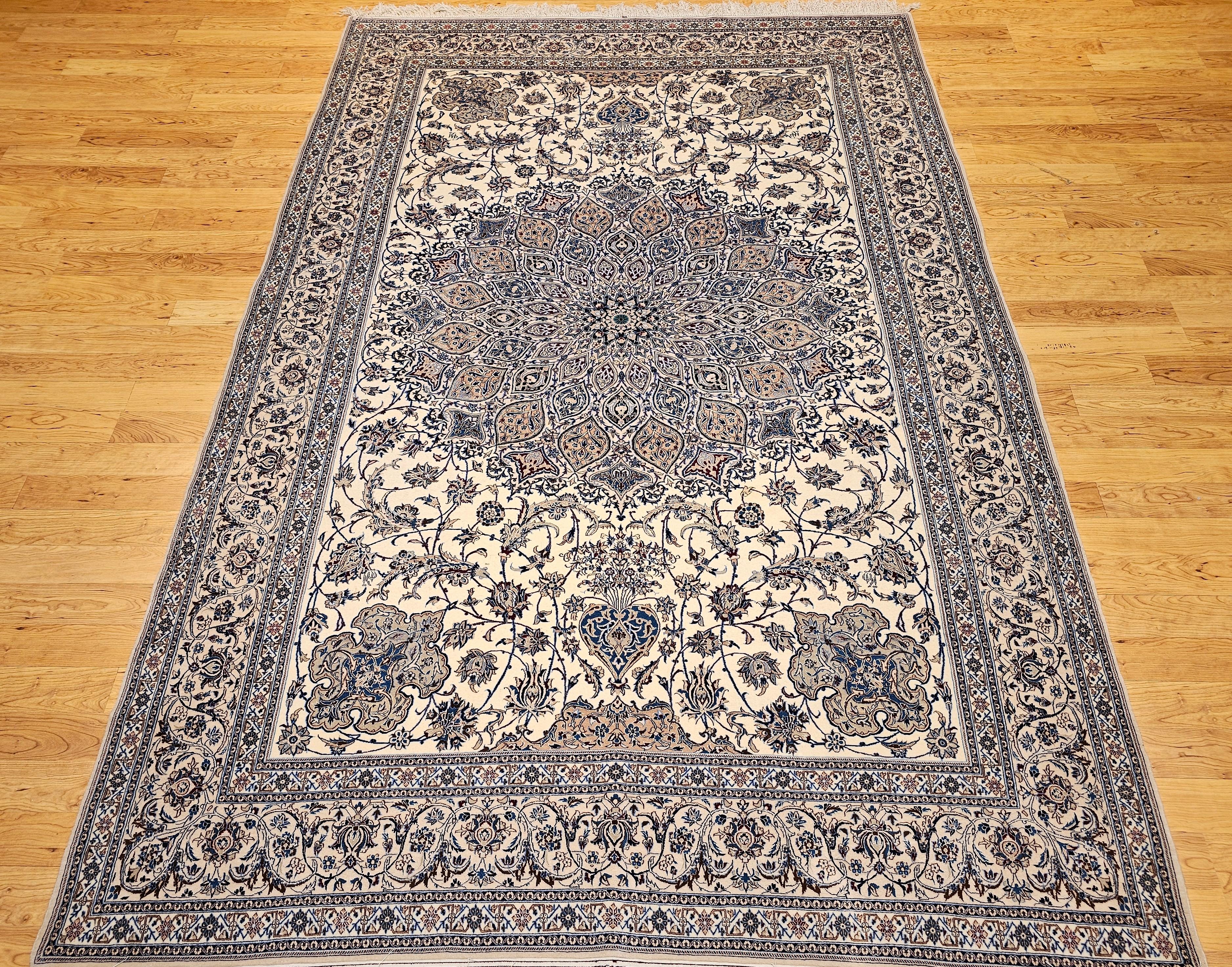 Extra fine weave hand-knotted room size-rug Persian Nain from the 4th quarter of the 1900s.  The Nain is in a floral medallion pattern with an ivory background, with a pale tan border and design accent colors in French blue, pale brown, and ivory