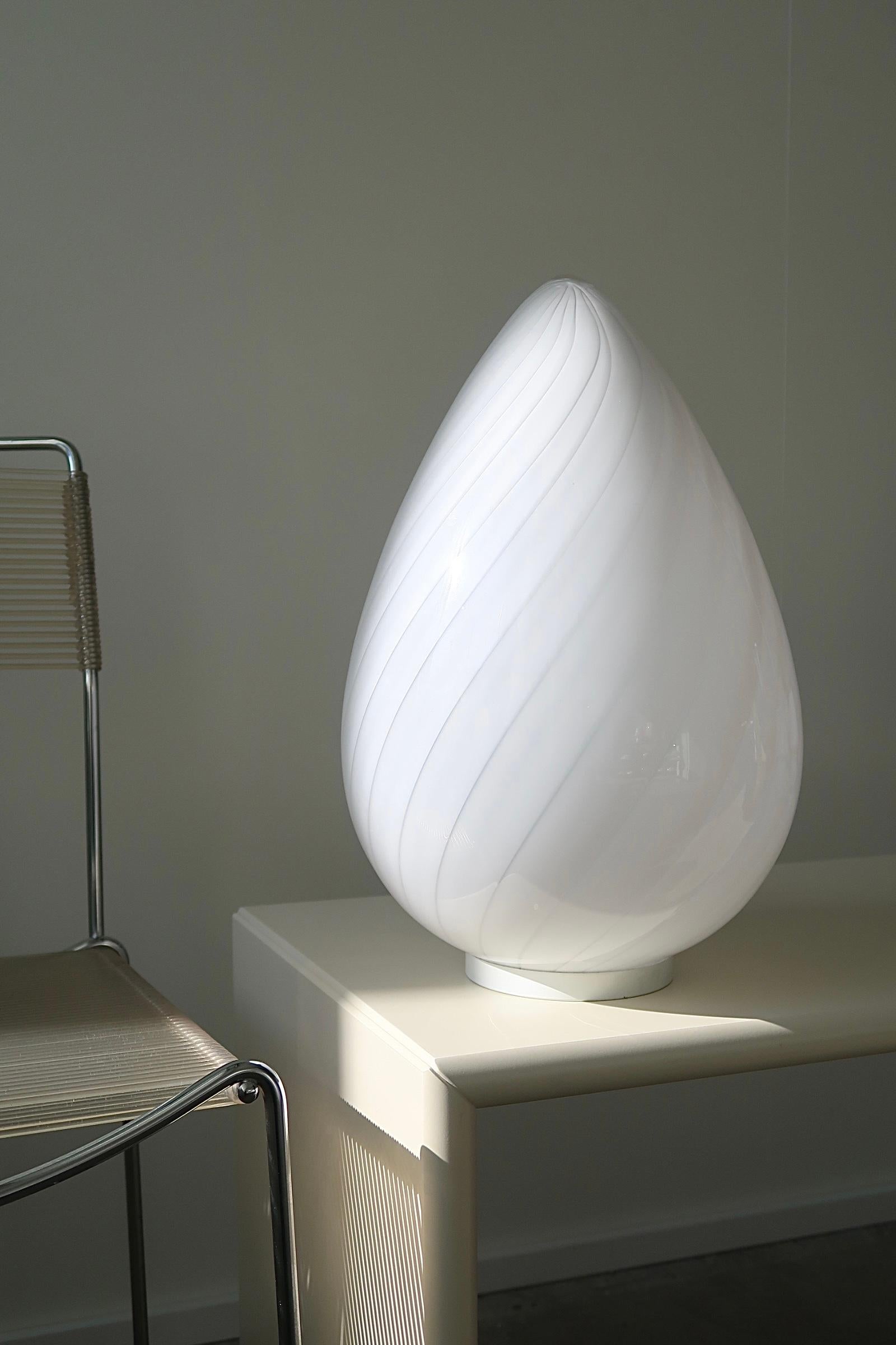 Vintage Murano egg lamp that can be used as a table lamp or floor lamp. Mouth blown in white opal glass with swirl in a beautiful oval shape like an egg and is therefore known as ''egg lamp''. An absolutely fantastic, sculptural lamp. Handmade in