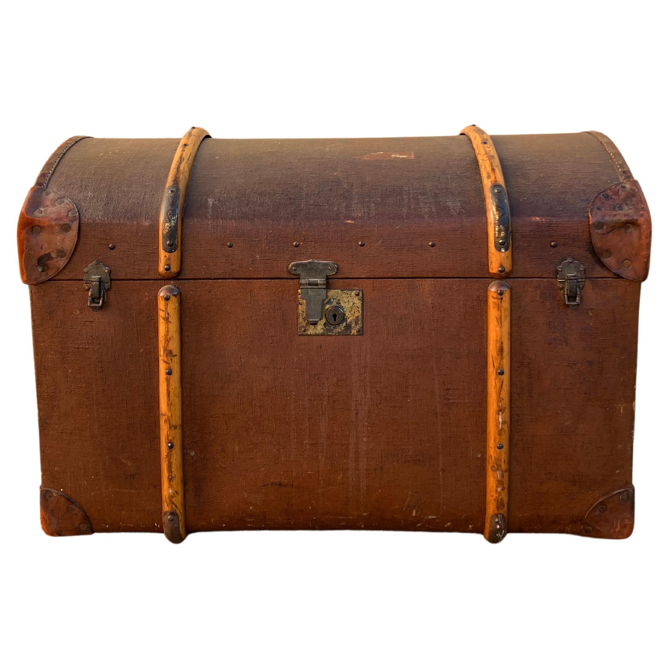 A gorgeous Victorian extra-large travel trunk. The antique trunk has an attractive dome top and is bound with wood. The handles on the sides are made of thick leather and are in great condition. The case has two side latches on the front and a large