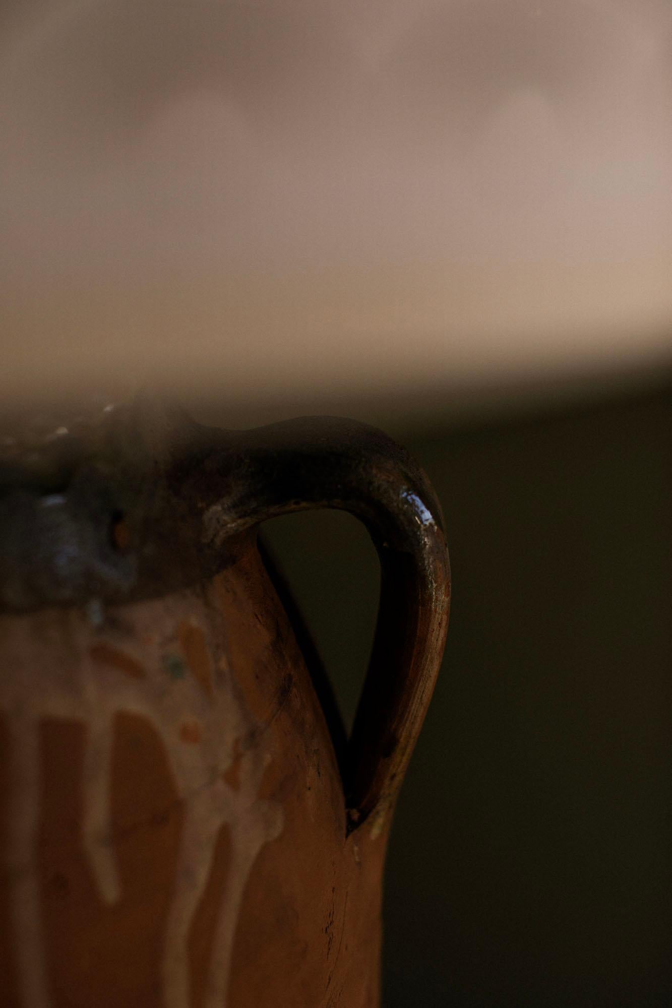 A large vintage Turkish terracotta table lamp featuring a rich chestnut-toned finish and traditional twin-handled form. Handmade using Anatolian techniques, this lamp shows natural surface wear and character typical of vintage pottery, offering