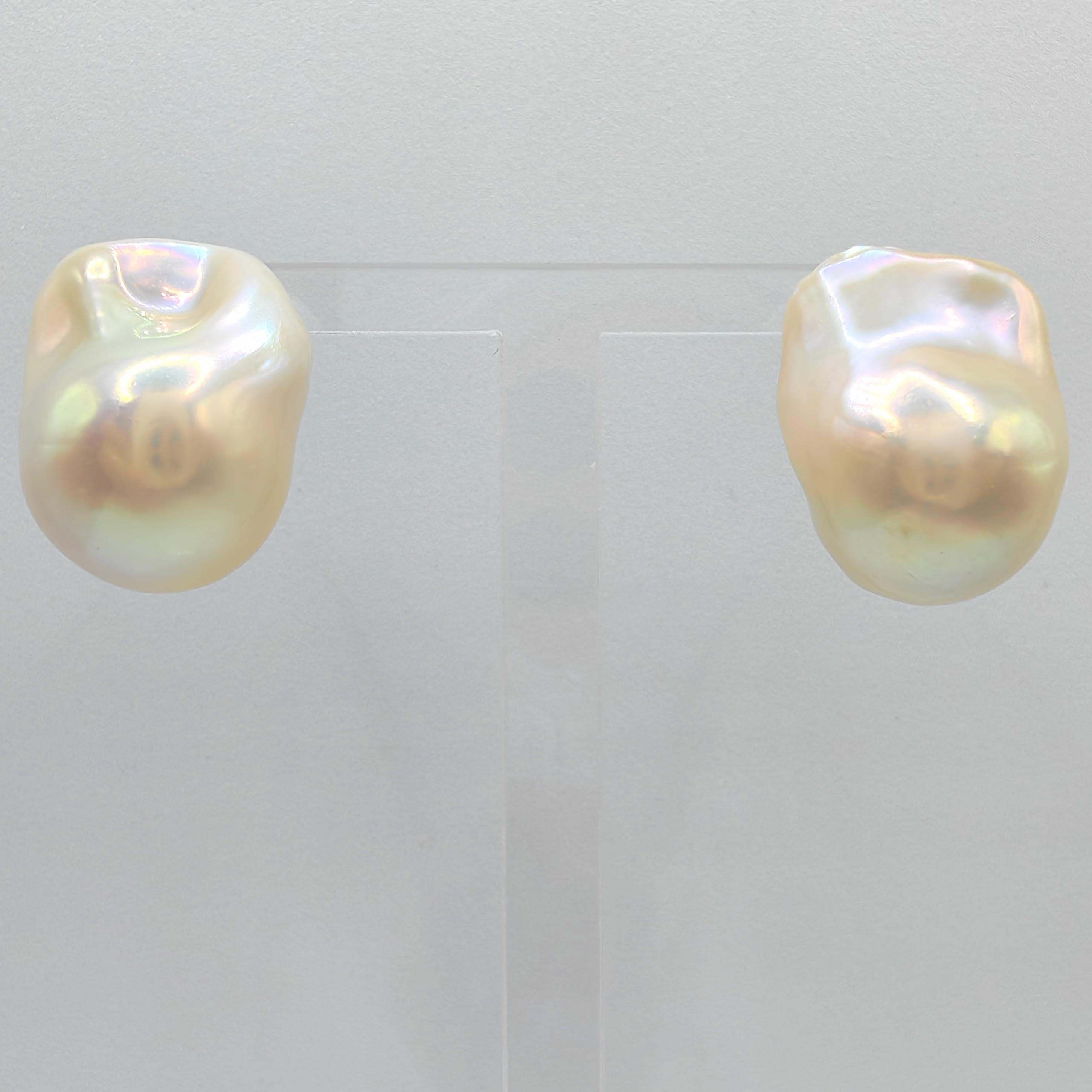 Indulge in the enchanting allure of our Extra Large 21mm Iridescent White Baroque Pearl Stud Earrings. These captivating earrings feature two mesmerizing freshwater cultured baroque pearls, radiating a creamy white glow and a captivating