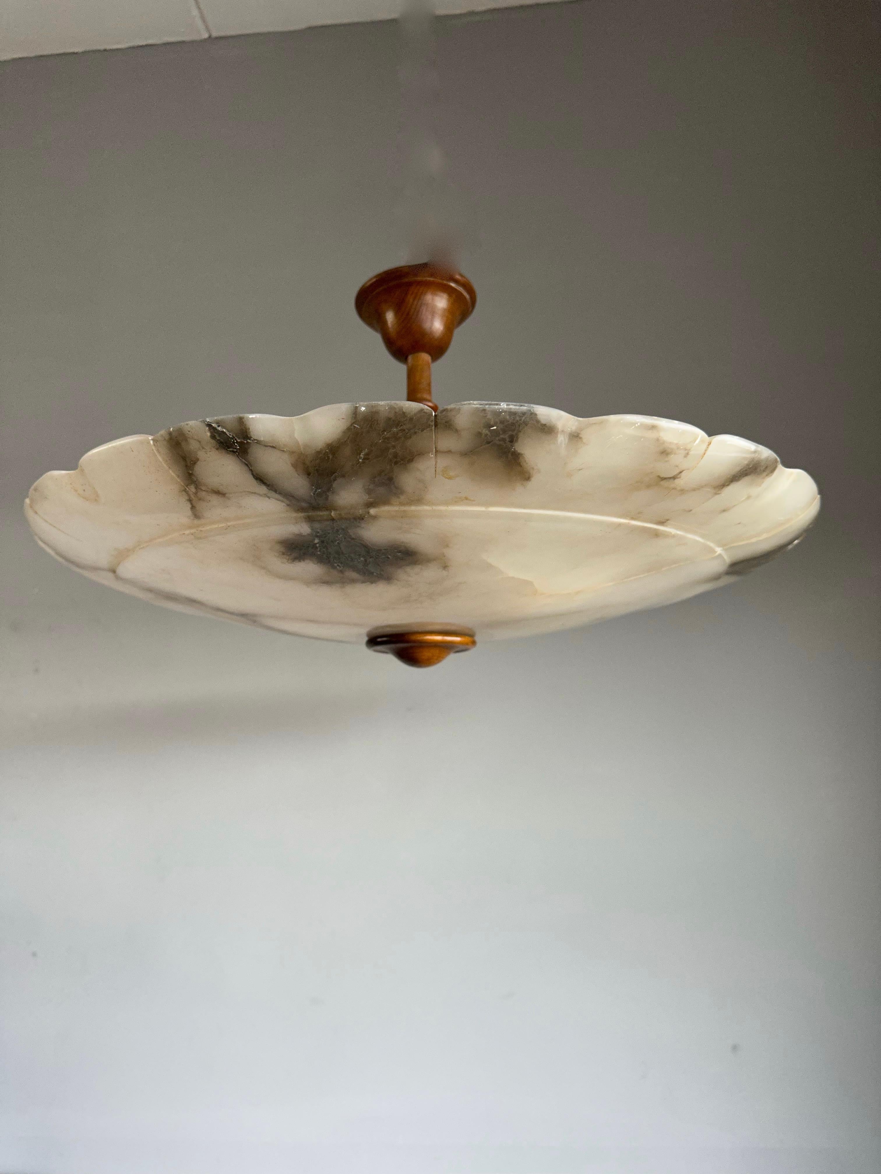 One of the largest antique alabaster flush mounts from the early 1900s.

This rare, almost flat and extra large size alabaster light fixture also is of a beautiful design. The beautiful and polished alabaster shade comes with flower petal like