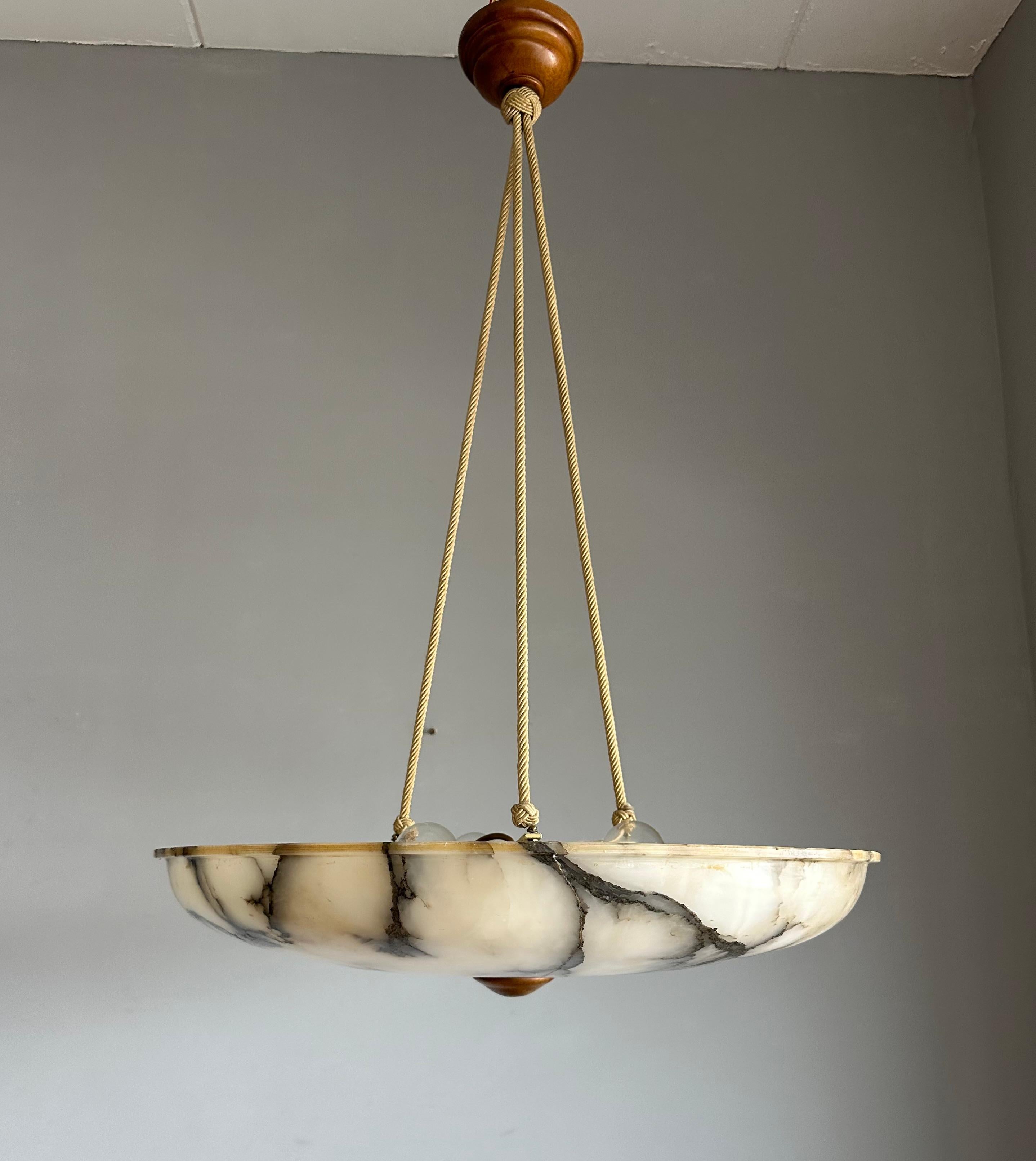 Rare and majestic, three light alabaster pendant from the heydays of the Art Deco era.

This rare and very large size Art Deco pendant light comes with a stunning design and polished alabaster shade. This large size and almost flat alabaster shade
