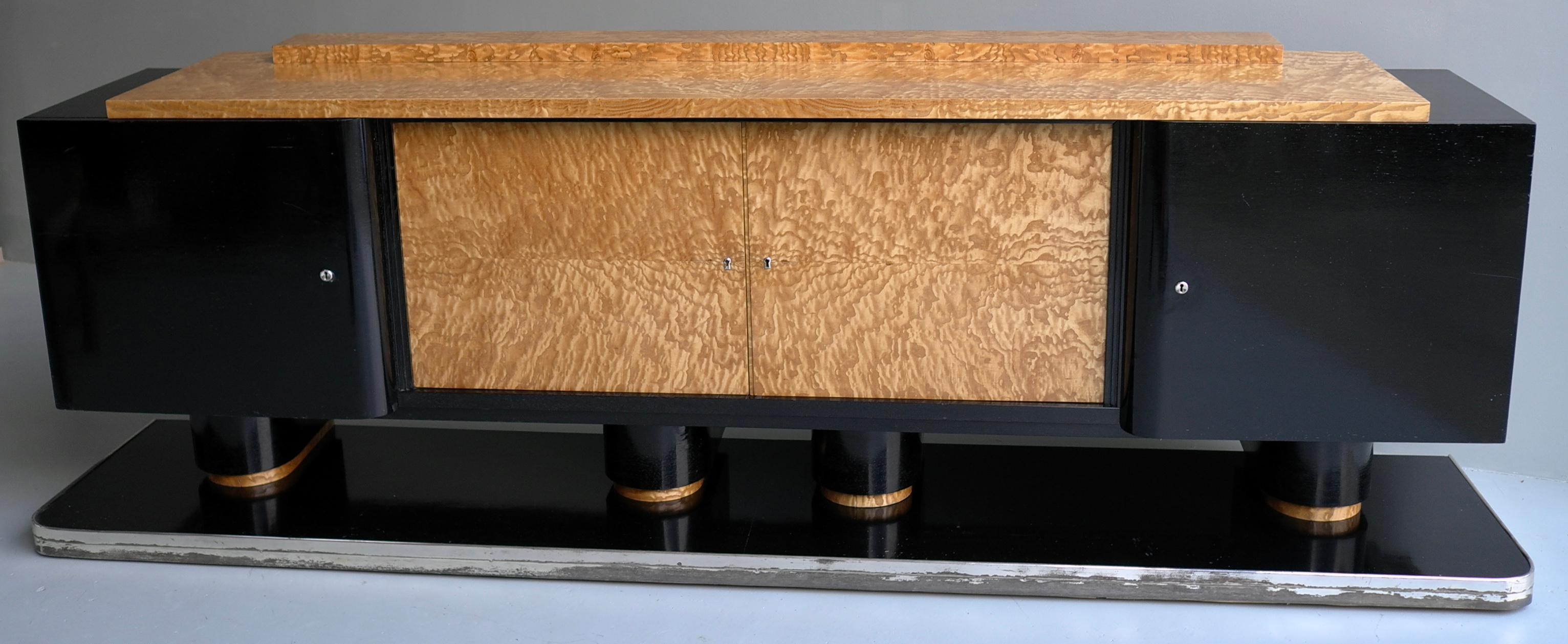 Credenza Art Deco extra large in legno nero e radica, Francia, anni '30. 

Impressionante la grande credenza, grazie alle quattro colonne nere sembra galleggiare. Il precedente proprietario l'ha acquistata da un vecchio Hotel architettonico in