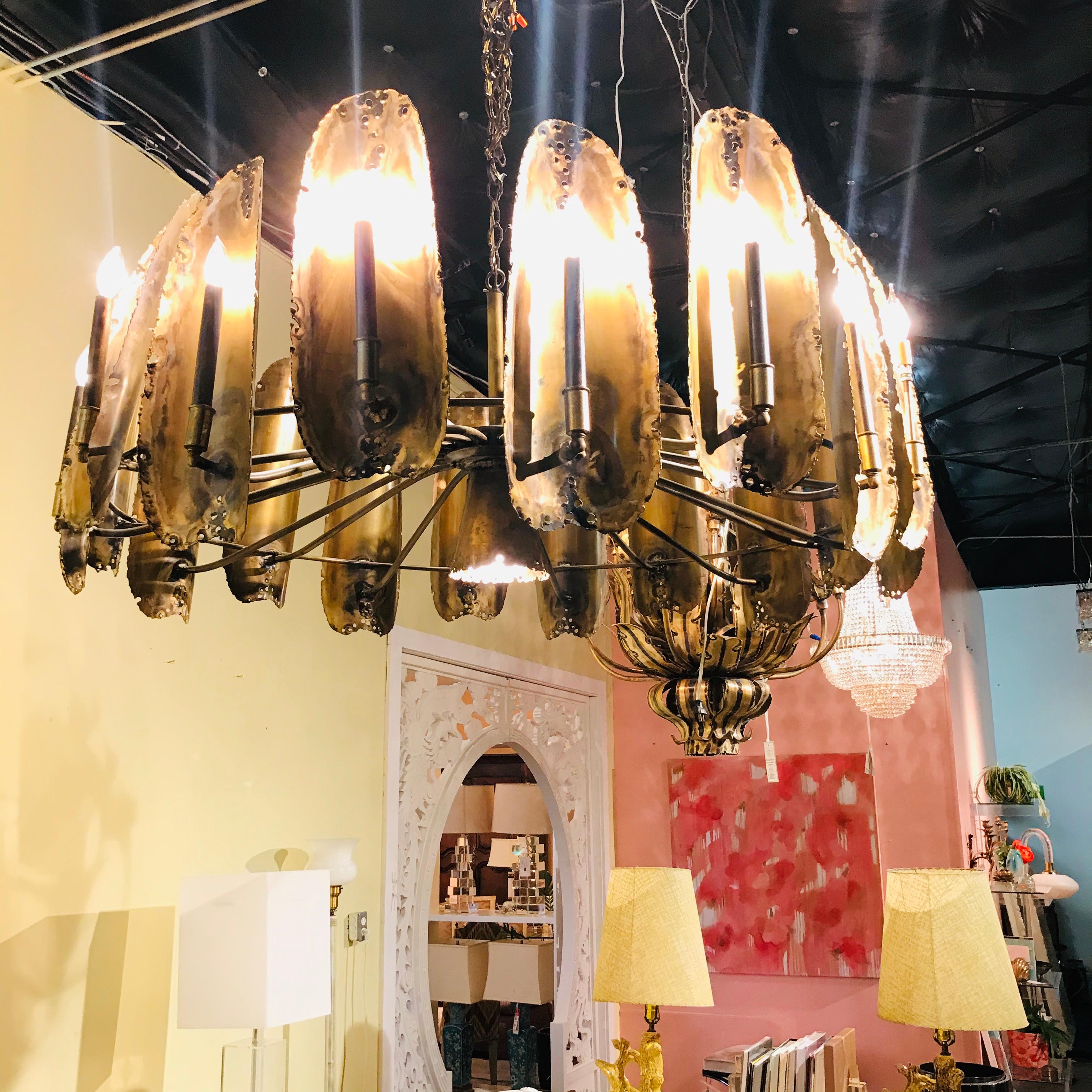 Stunning, extra-large Brutalist midcentury chandelier designed by Tom Greene for The Feldman Co. in the 1960s. There are 18 smaller lights encircling a cone downlight. Original condition with gorgeous patina! 48