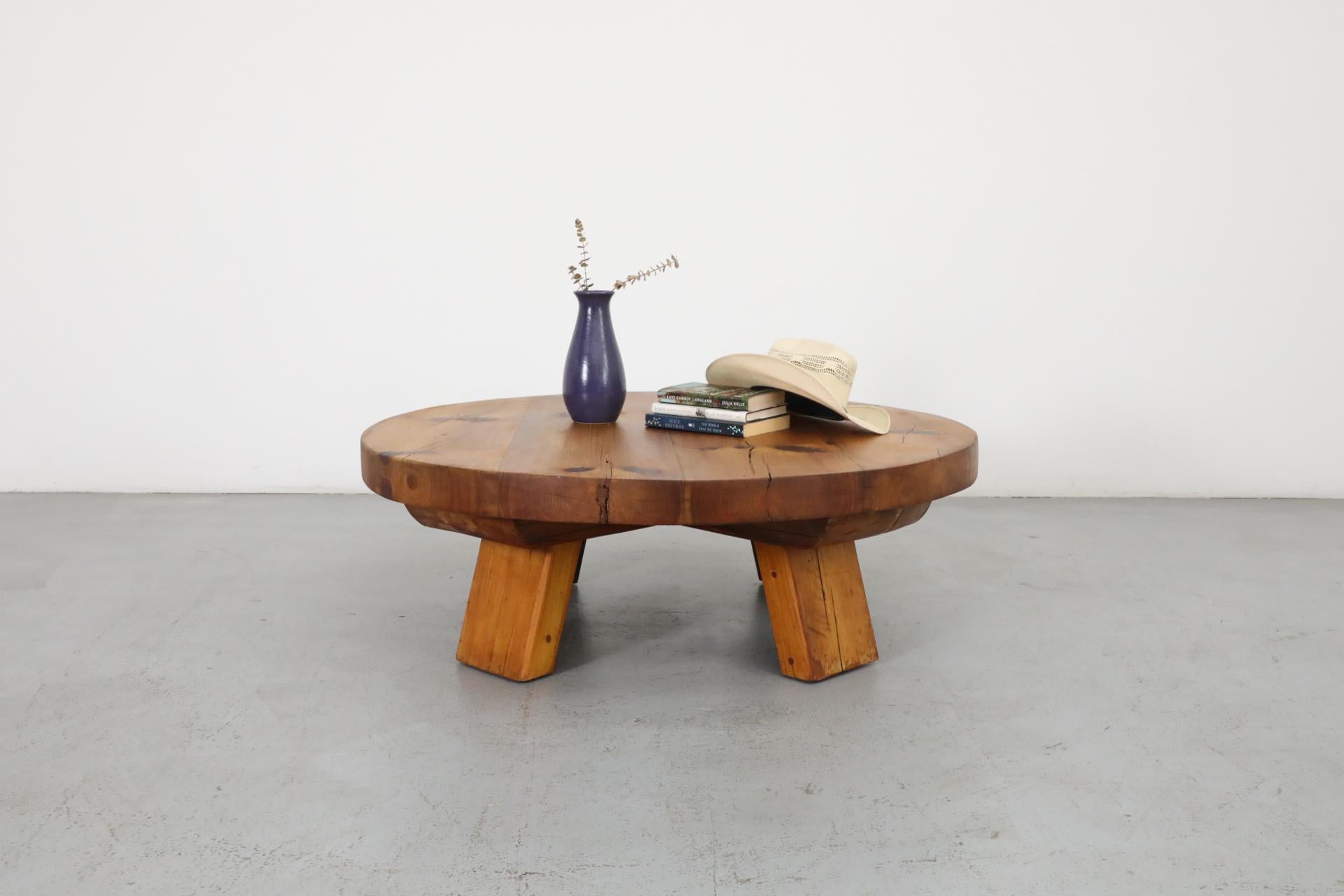 Beautiful Brutalist coffee table with substantial size and weight in natural Fir wood with round top and thick slab legs. In original condition with wear and patina consistent with age and use.