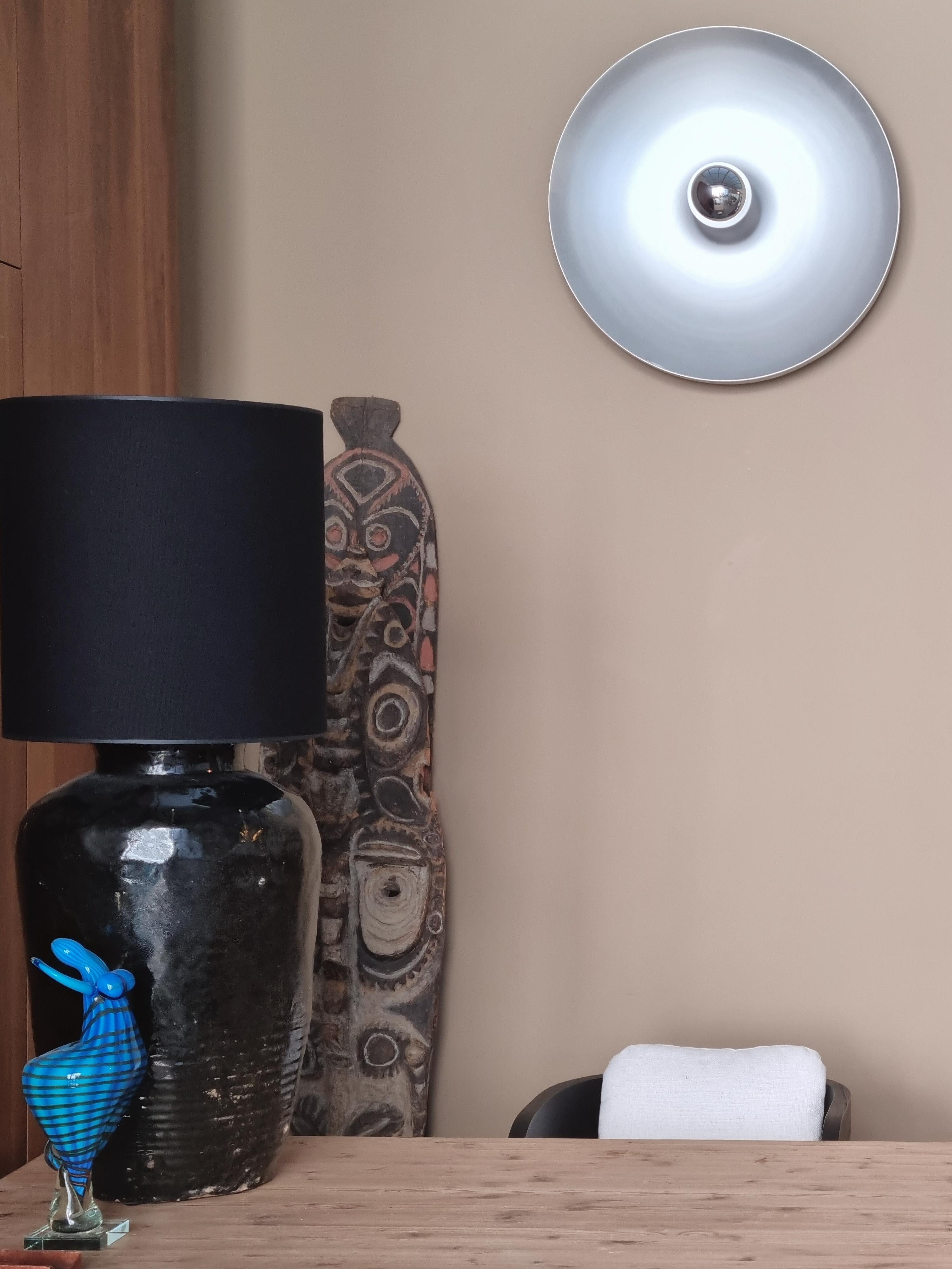 Este llamativo aplique de pared presenta un diseño sofisticado y minimalista caracterizado por un único disco de aluminio moldeado, bellamente emparejado con una bombilla de punta plateada. Sus líneas elegantes y su estética atemporal evocan el