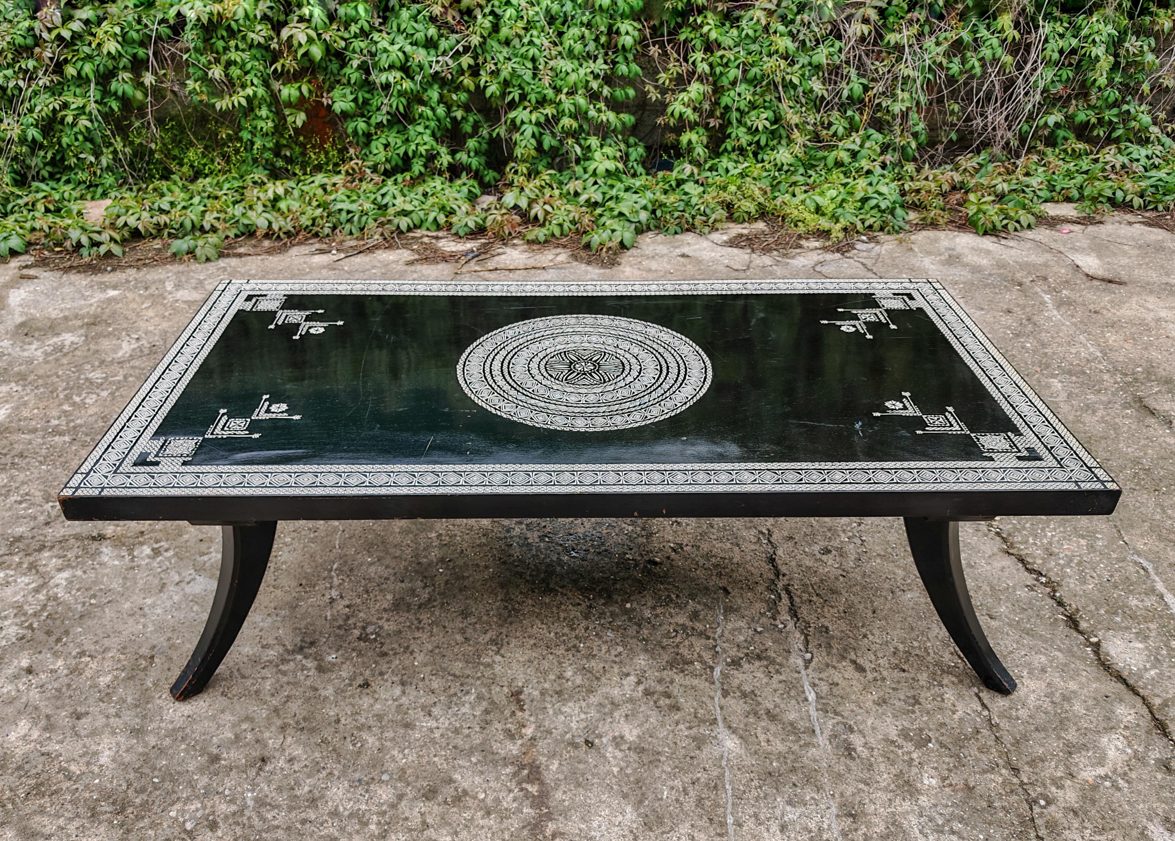 Vous trouverez dans cette annonce une extraordinaire table basse ancienne de grande taille, conçue par Ettore Zaccari, un maître italien, en 1905. Il est en chêne massif et laqué noir. La table présente des ornements sculptés à la main en couleur