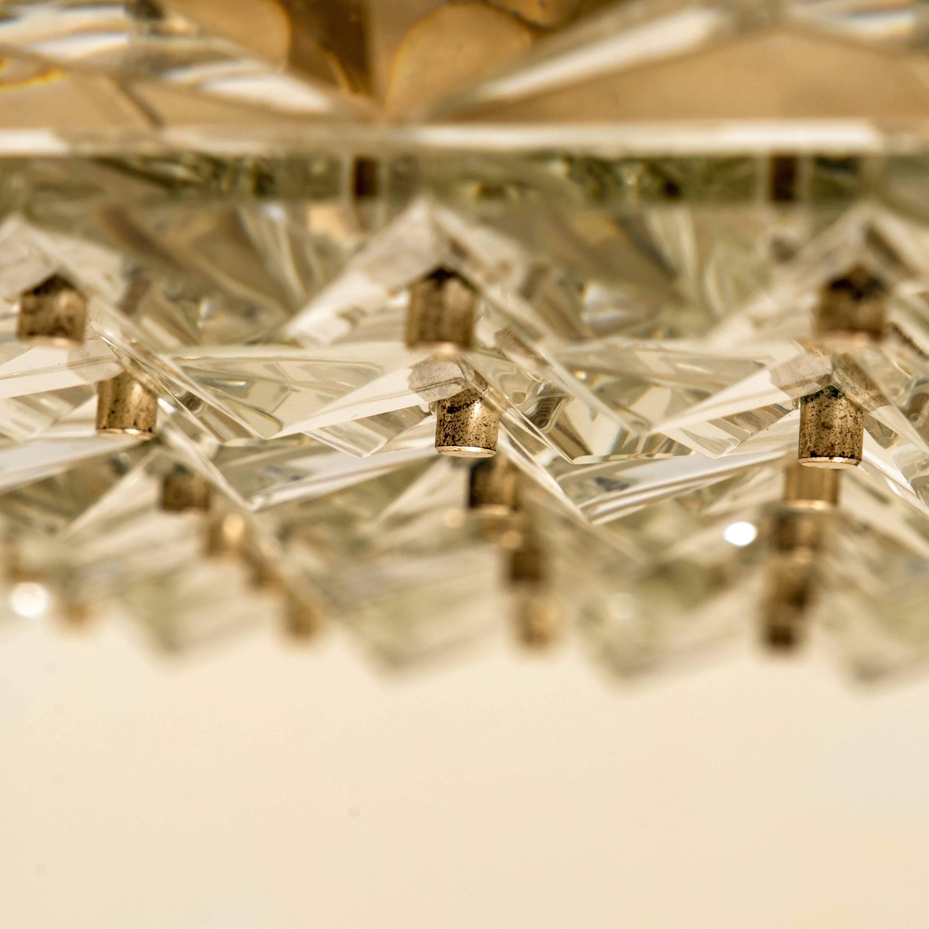 This unique modernist design chandelier was designed by the Kalmar during the 1960s, and manufactured in Austria. The unique rectangular crystals are meticulously cut in such a way that radiate the light of the bulbs in different directions. We can