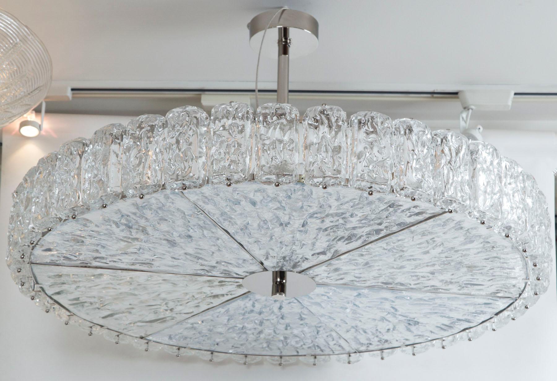 This shimmery nickel-ed ceiling fixture blown to appear as if constructed from blocks of ice is comprised of 46 separate glass pieces and is set into a nickel frame and electrified to code with 6 medium base sockets for even illumination. UL