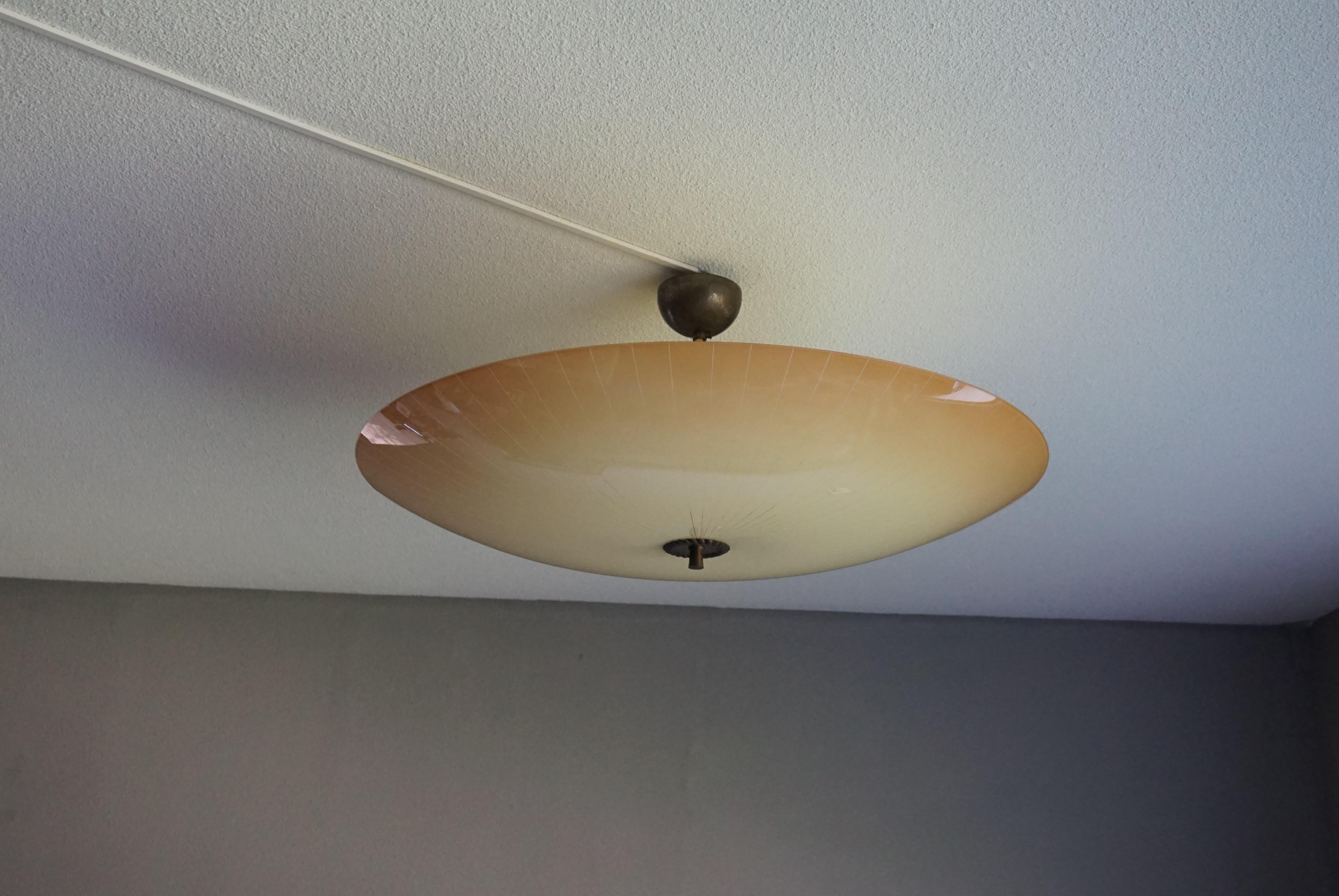 Impressive Mid-Century Modern ceiling lamp.

This rare size light fixture has a beautiful look and feel and you will hardly ever find a light fixture from the Mid-Century Modern era with a larger and more stylish glass shade. If you want to get a