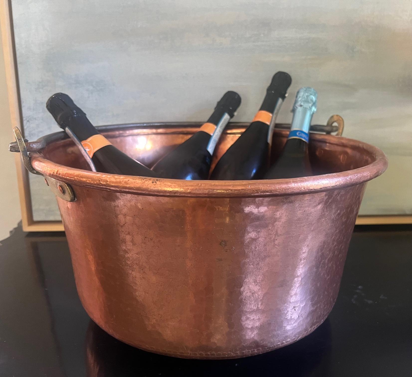 Extra large antique French copper and brass cauldron with a forged iron handle. The copper is hand hammered, the handle and brass pieces are hand forged and the pot is stamped with a 47. 
Great piece to for decoration or to be used as a wine bucket