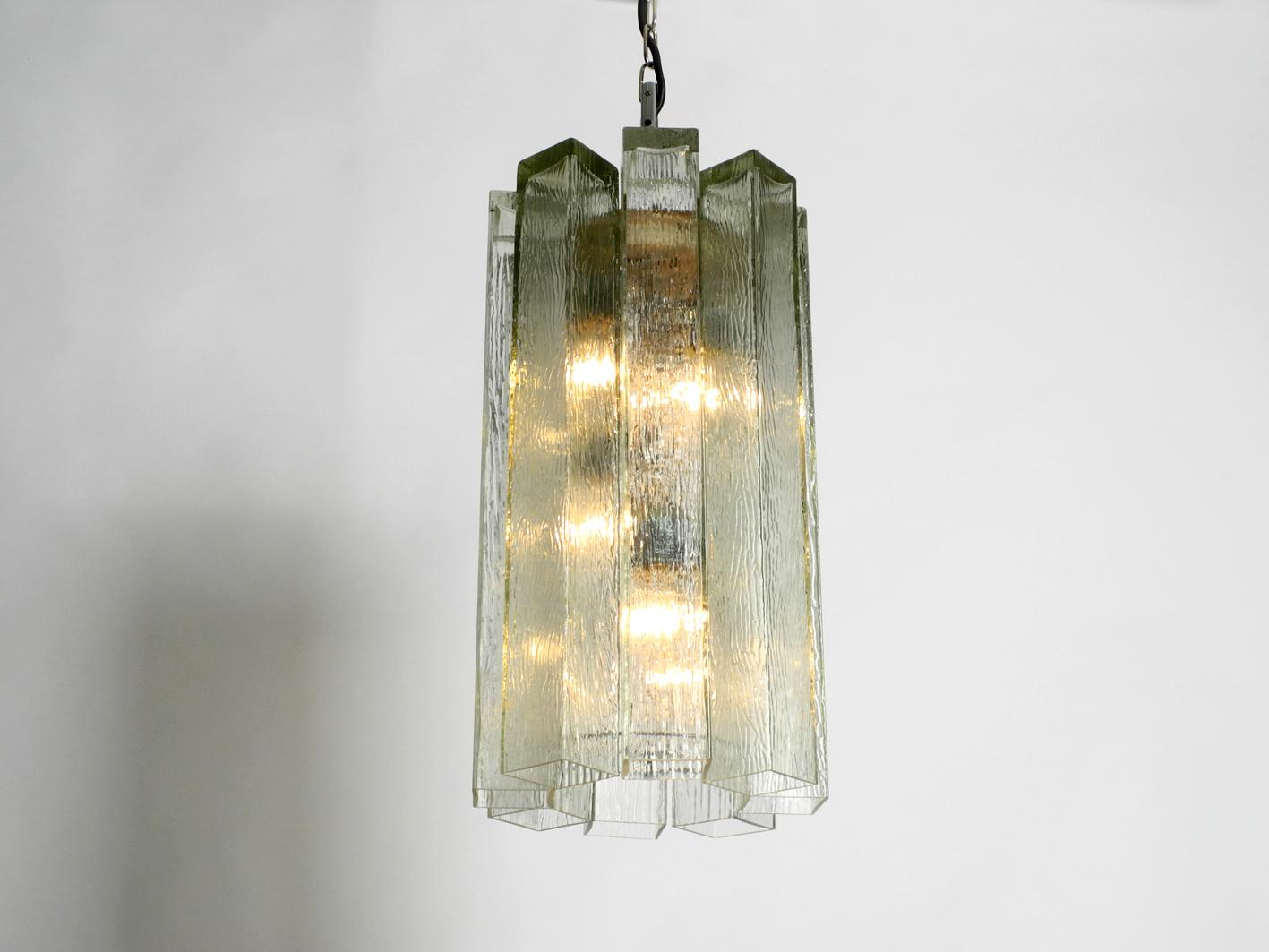 Very high quality rare Mid-Century Modern large glass pendant lamp by Doria.
Very classy minimalistic 1950s Brutalist design.
Eight long square massive glass elements in light green are hung in a like a star.
Makes a great charming light and is