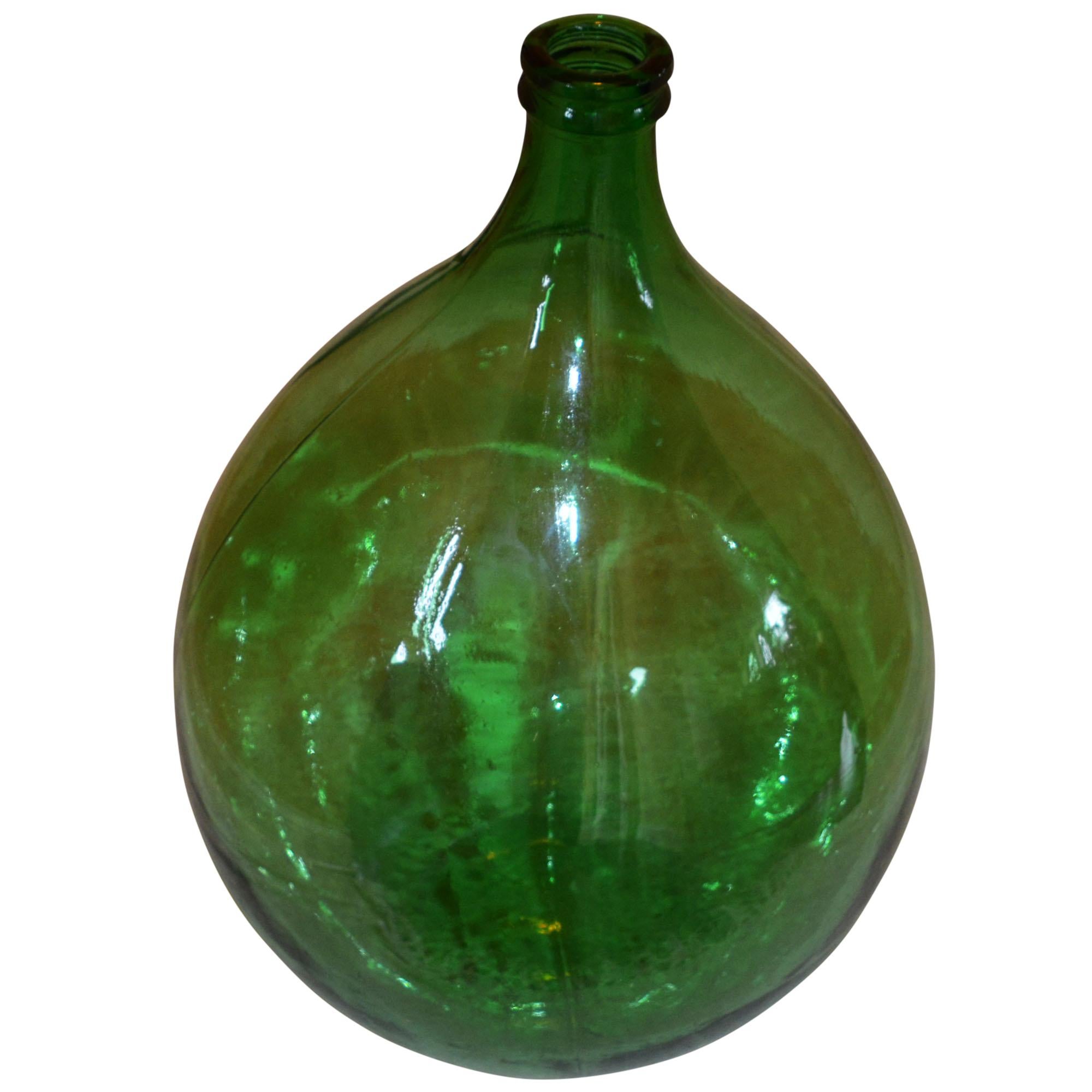 Extra-large, hand blown green glass demijohns from the late 19th century. Near-perfect balloon made of smooth green glass. These were commonly used to hold the house wine reserves in a cellar or perhaps a cool, dark room off the kitchen.
    
  