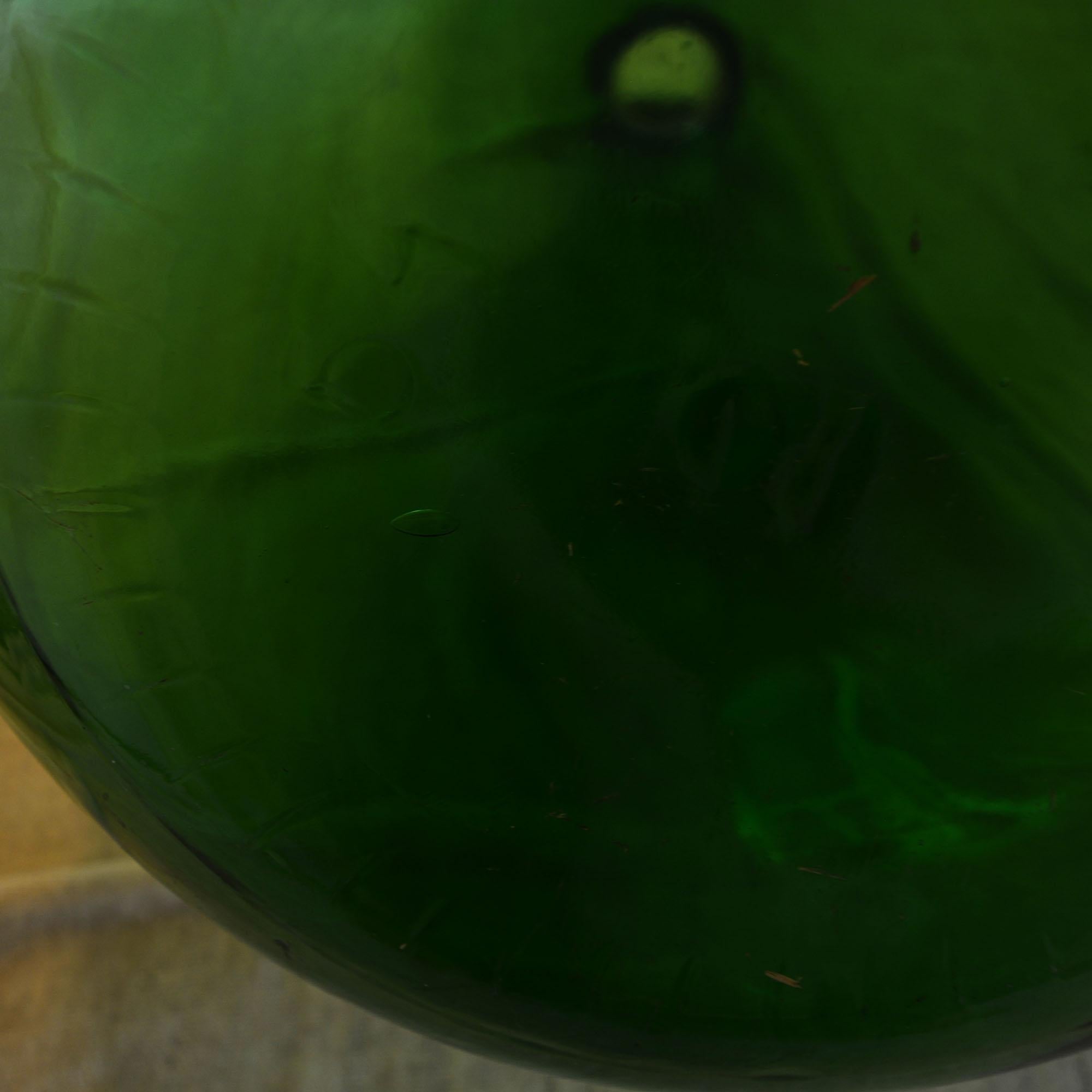 Extra-large, hand blown green glass demijohns from the late 19th century. Near-perfect balloon made of smooth deep-green glass and marked 