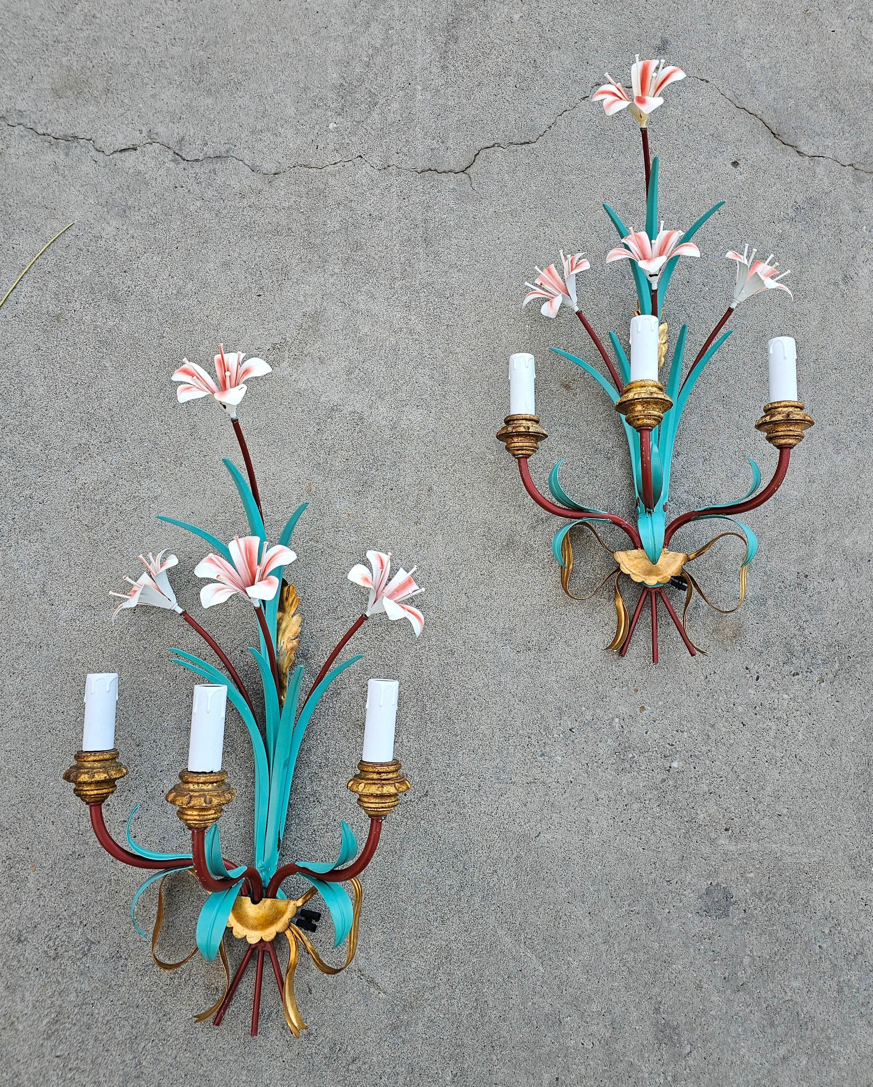 In this listing you will find a pair of extraordinary painted and partly gold plated Tole sconces shaped as Lilly flowers. Each feature 3 lights, planted onto gold plated wooden decorative buds. The bulbs they require are model E14, available