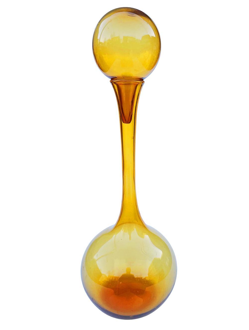 A massive and impressive glass decanter attributed to Empoli in Italy. Very much in the style of Blenko Glass. It consists of sculptural handblown amber glass with large stopper.