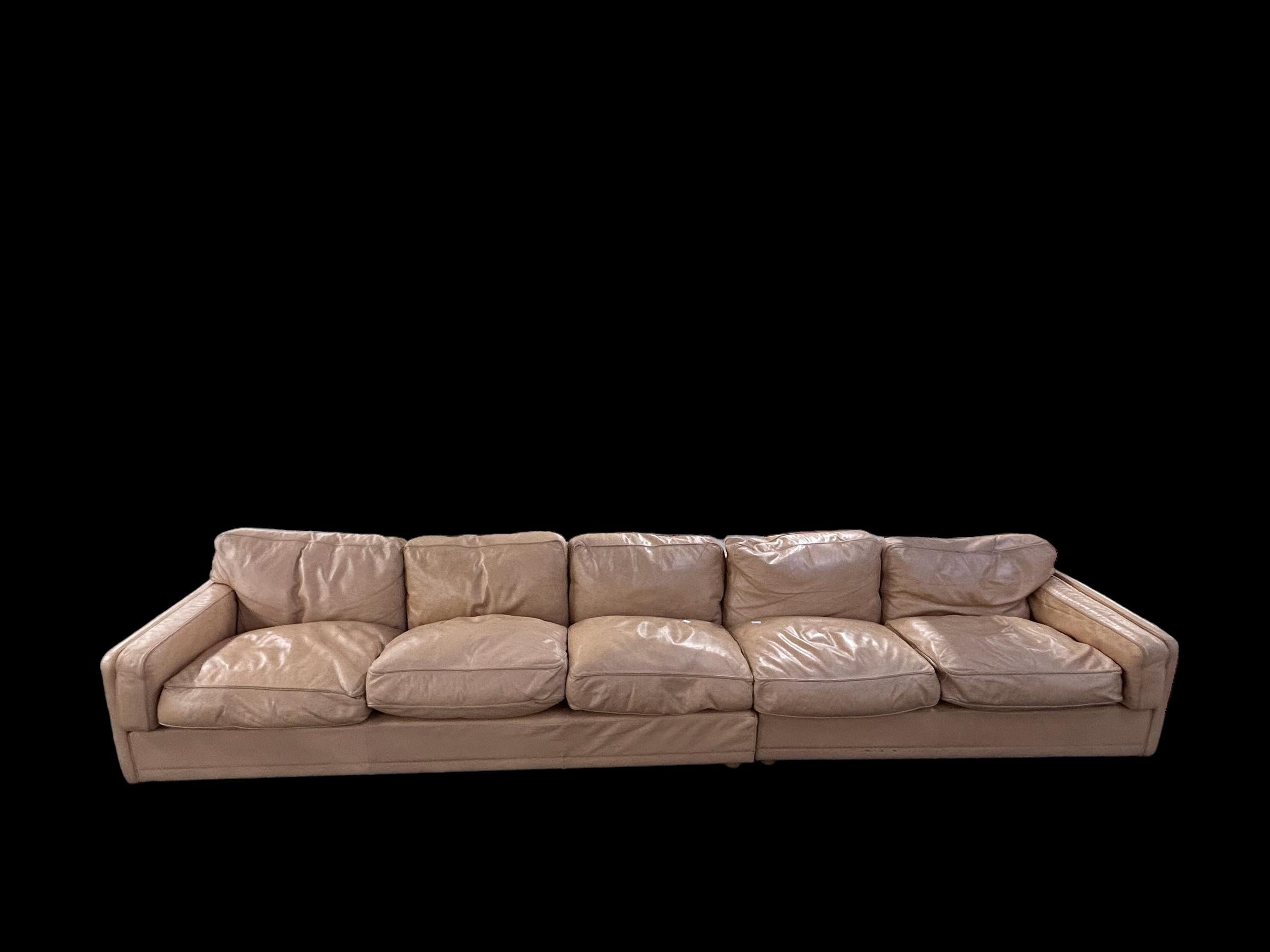 Sofá icónico fabricado por Poltrona Frau en los años 70 en piel beige con grandes cojines acogedores
El sofá se compone de dos piezas (220 cm y 160 cm) que pueden mantenerse unidas o utilizarse en ángulo con la mesa de centro a juego. 

