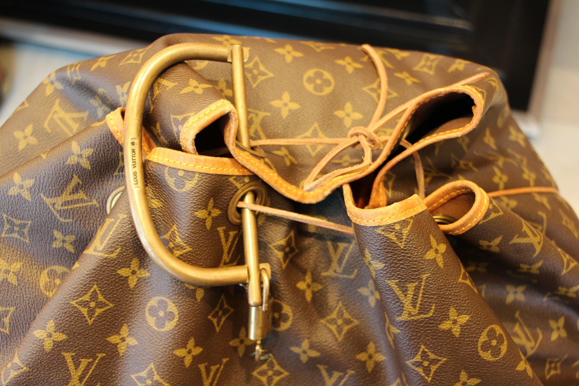 This impressive 1970s Louis Vuitton bag features monogram canvas in very good condition, its leather part has very few stains and scratches. Its interior is in very good condition too.
It comes with a replaced leather string, a solid LV brass handle