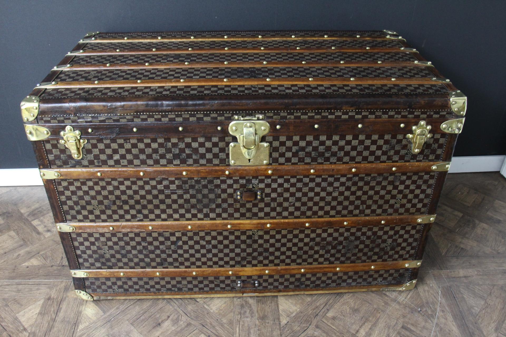 This superb Louis Vuitton steamer trunk features the very sought after checkers canvas, all leather chocolate color trim, LV stamped solid brass locks and studs as well as solid brass side handles and brass corners. Its customized hand painted red