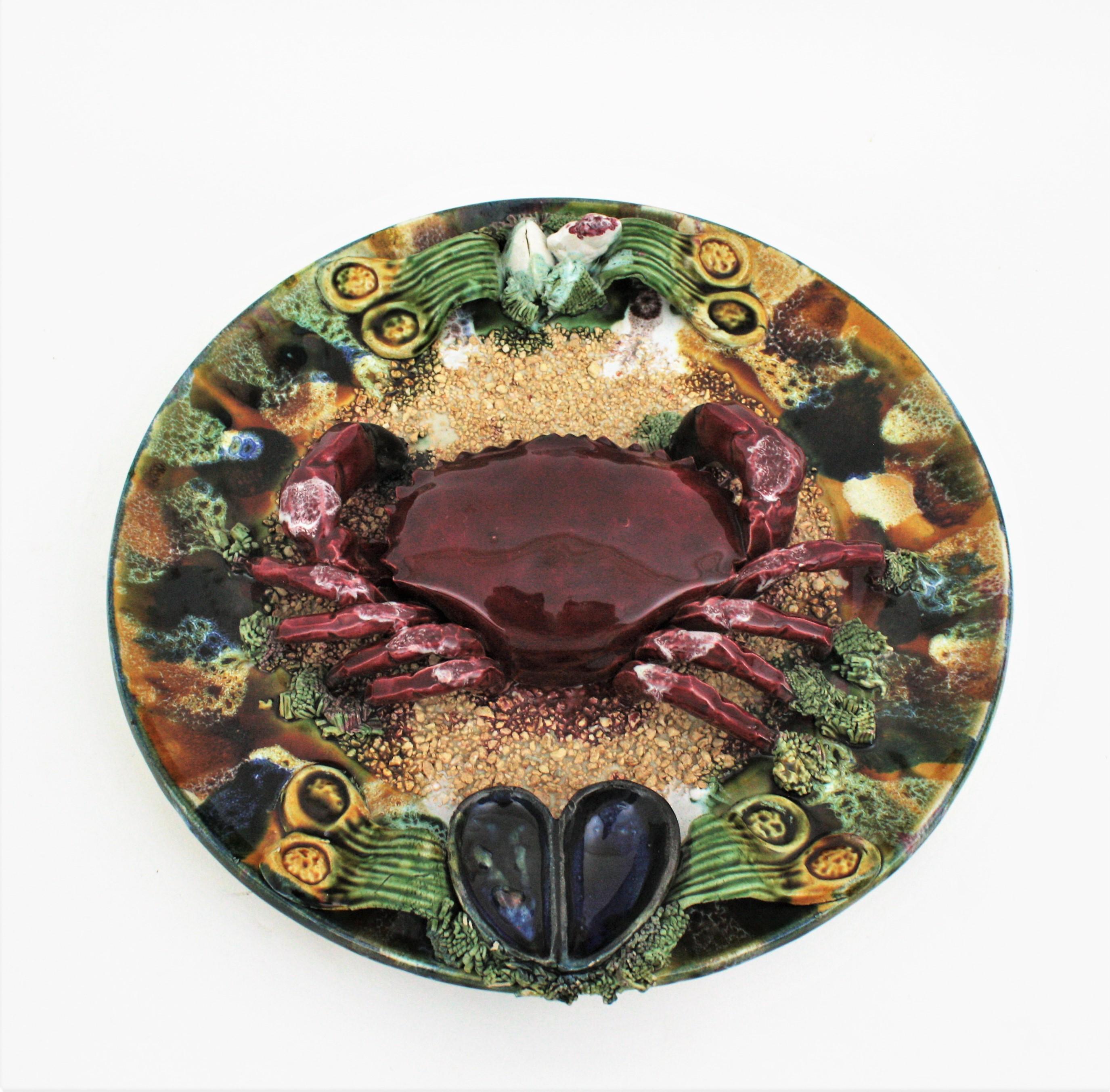 Impressive hand painted Majolica glazed ceramic crab and sea life trompe l'oeil wall plate, Portugal, 1940s-1950s.
Such a realistic representation with a crab on a sea landscape background.
This plate will add a cool midcentury accent in a beach