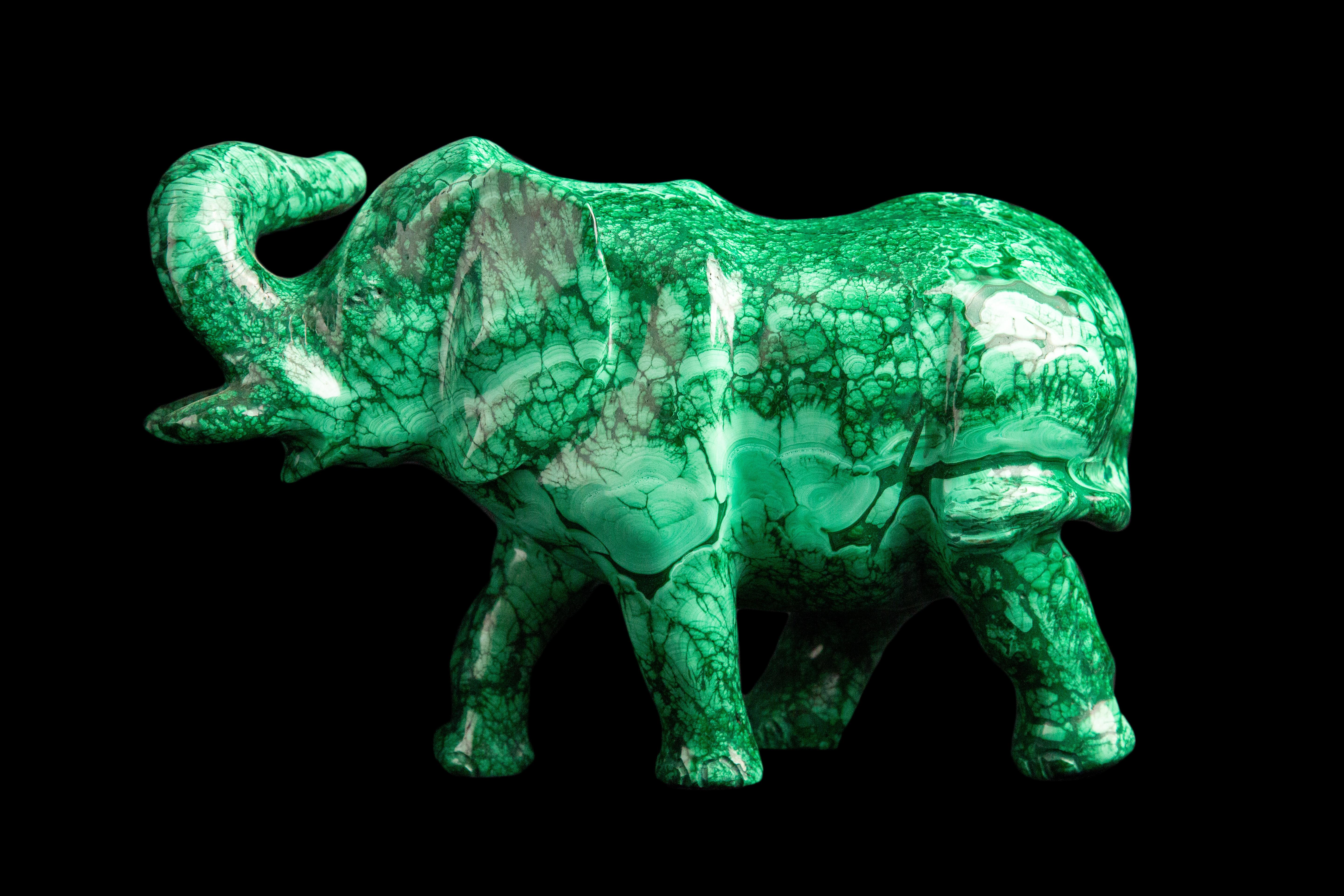 This exquisite hand carved malachite elephant is a unique and elegant piece of art that will enhance any space. The elephant symbolizes wisdom, strength and loyalty, while the malachite stone brings harmony, balance and protection. The rich green