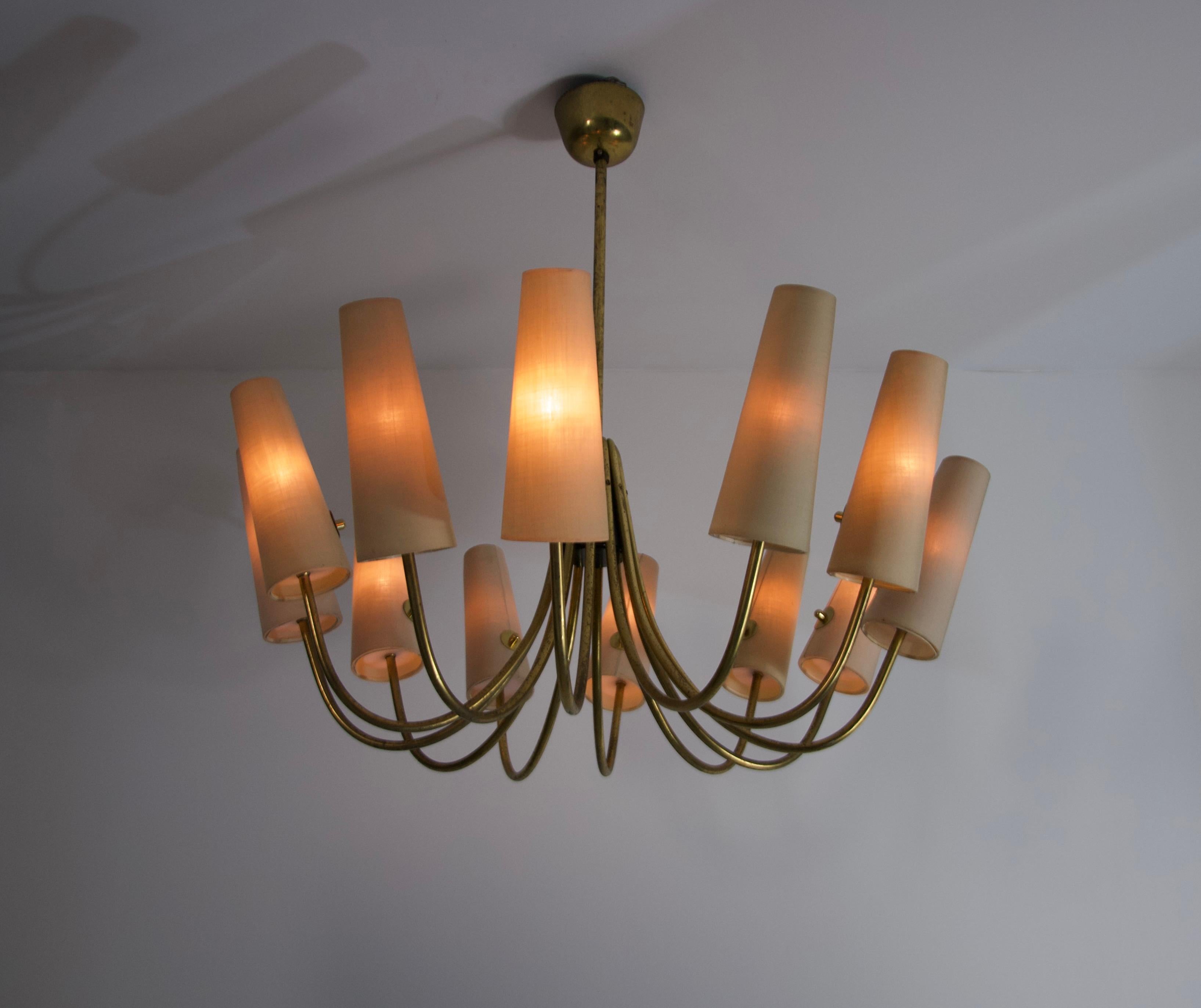 This stunning Sputnik-style ceiling lamp from 1950s Germany is a masterpiece of mid-century modern design, combining elegance with striking architectural form. The chandelier features a gracefully curved brass frame, radiating outward in a